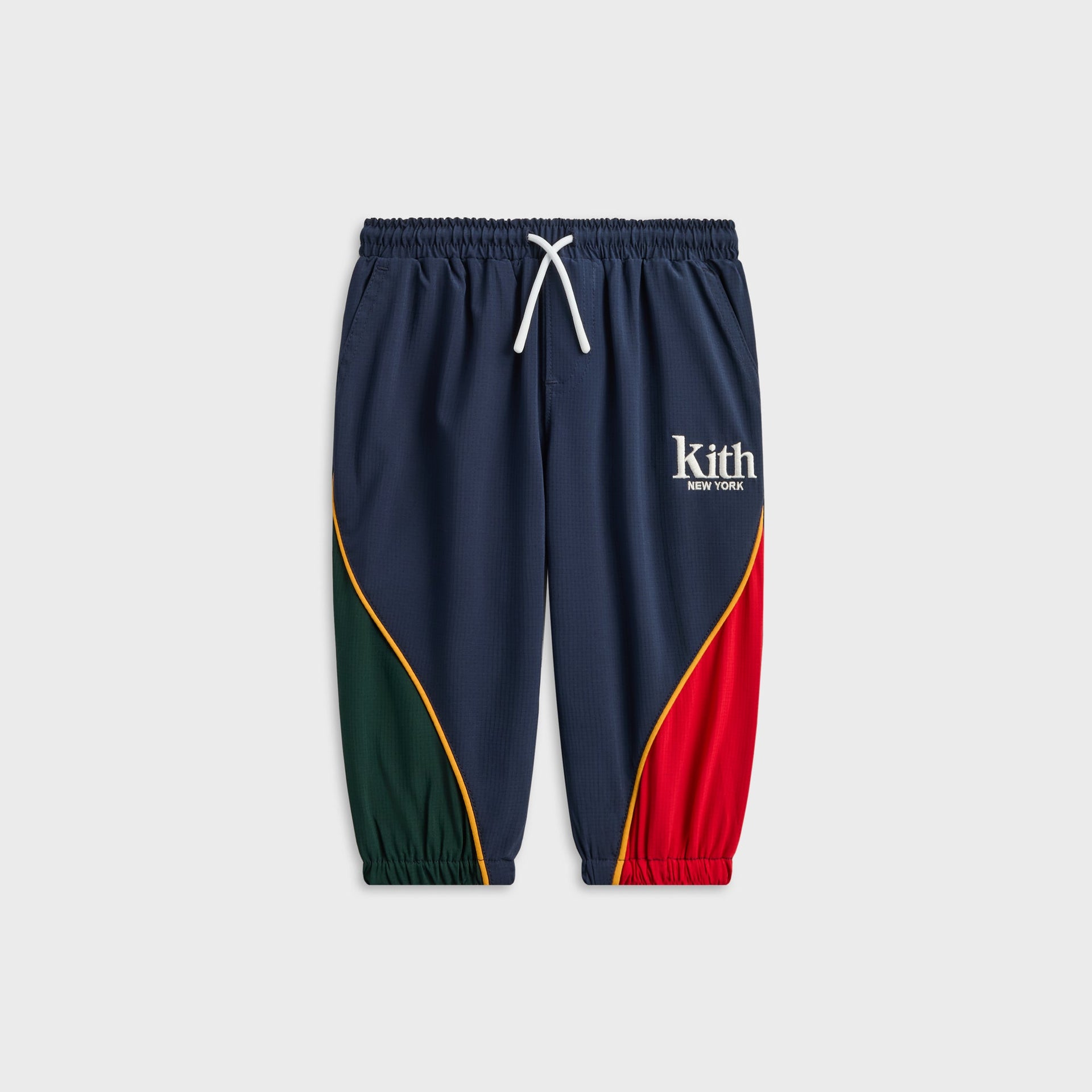 Kith Baby Mercer 8 Pant in Nocturnal navy, front view with green and red curved panels and drawstring