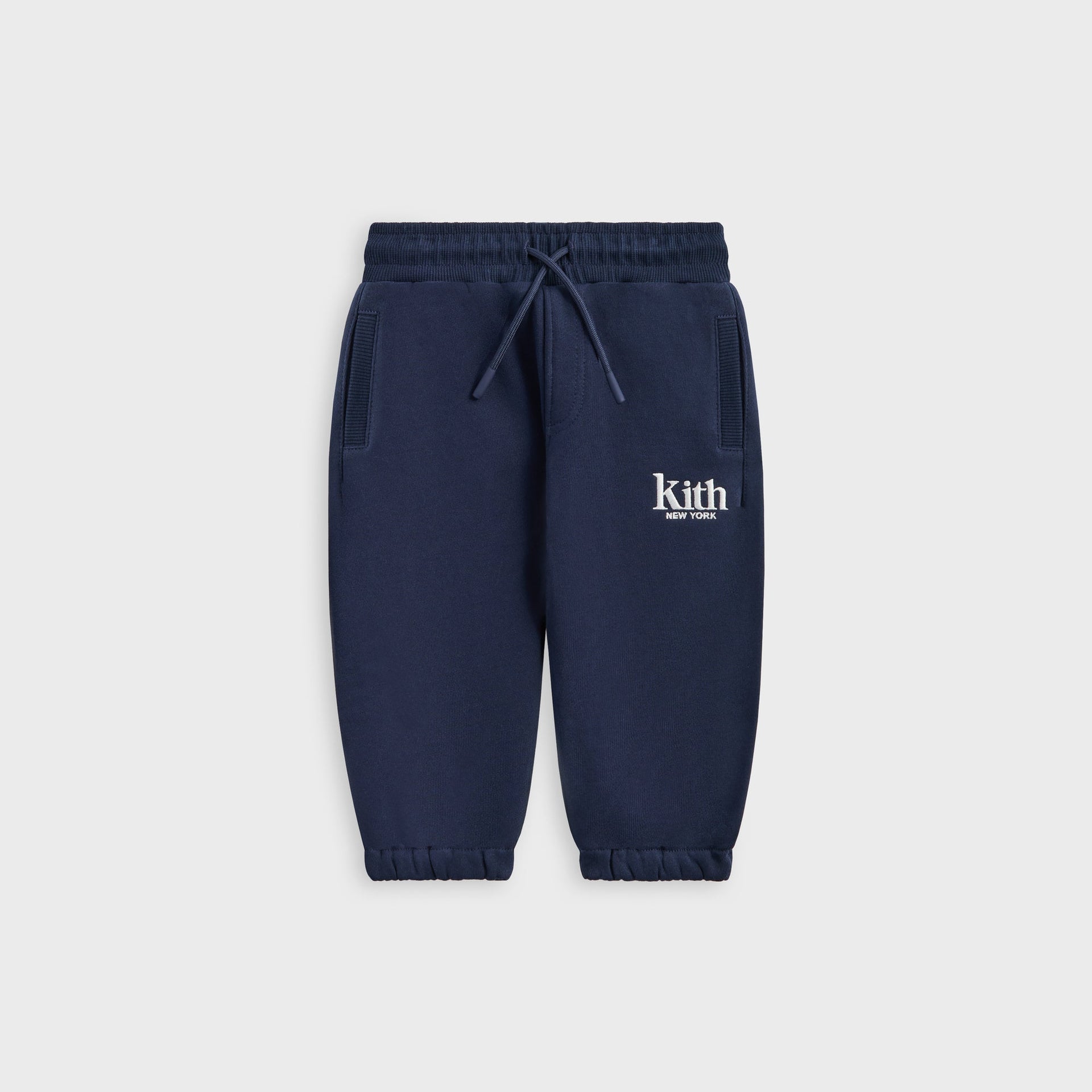 Kith Baby Williams II Pant in navy fleece, front flat lay with drawstring waist and white Kith New York logo