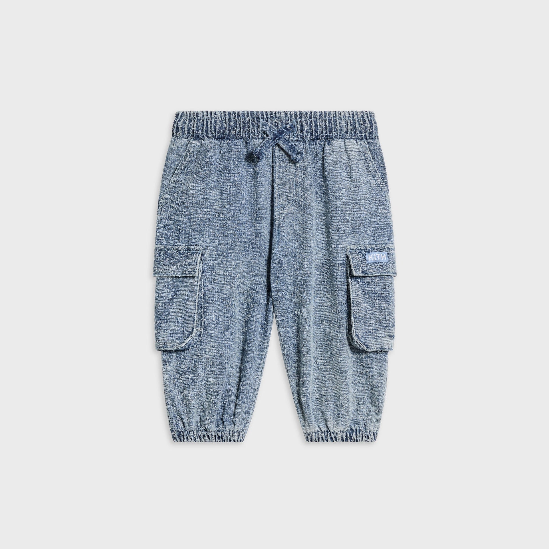 Kith Baby Textured Denim Chauncey Pant in Indigo, flat lay front view showing cargo pockets and elastic drawstring waist