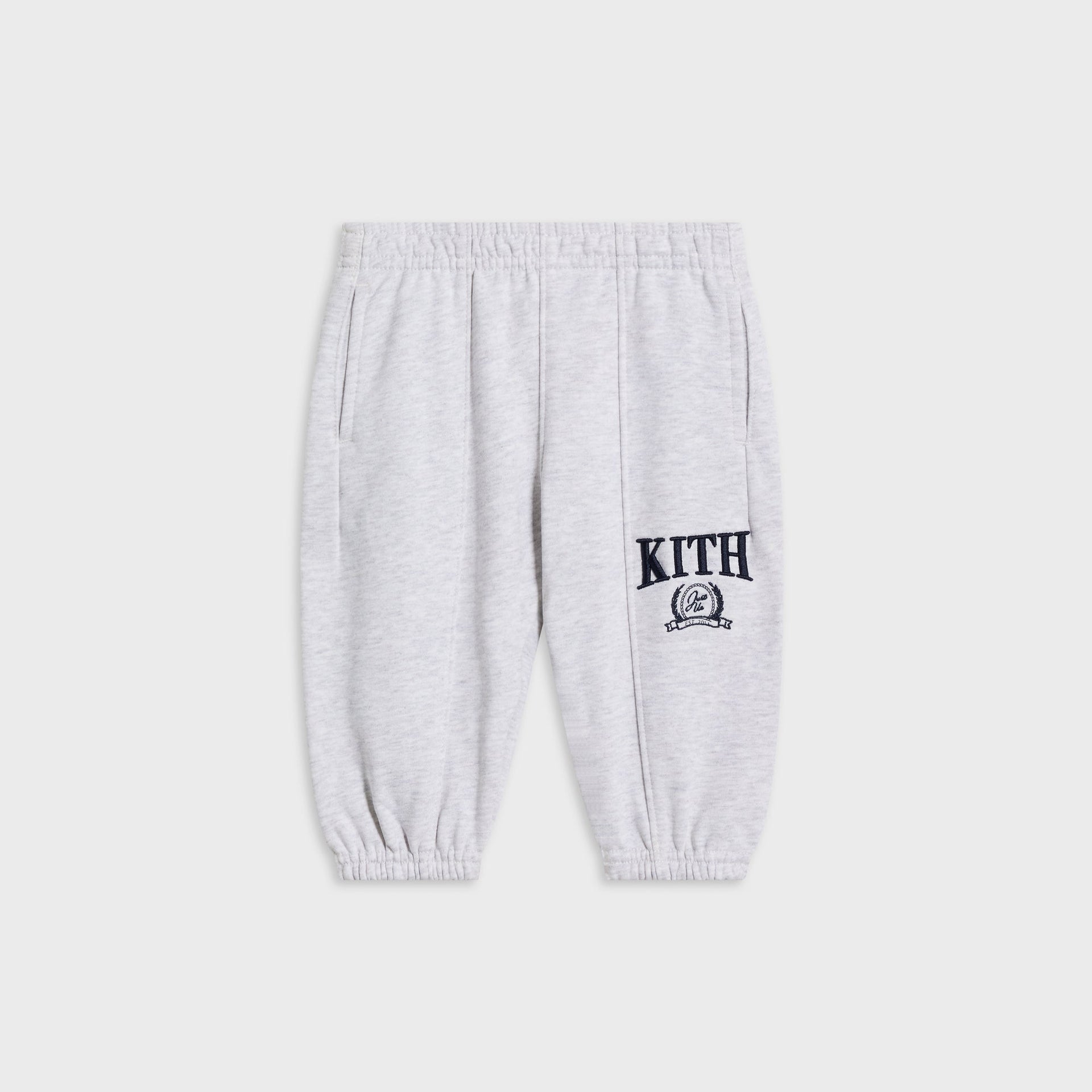 Kith Baby Collegiate Nelson sweatpant in light heather grey, flat lay with navy KITH crest logo above the ankle cuff