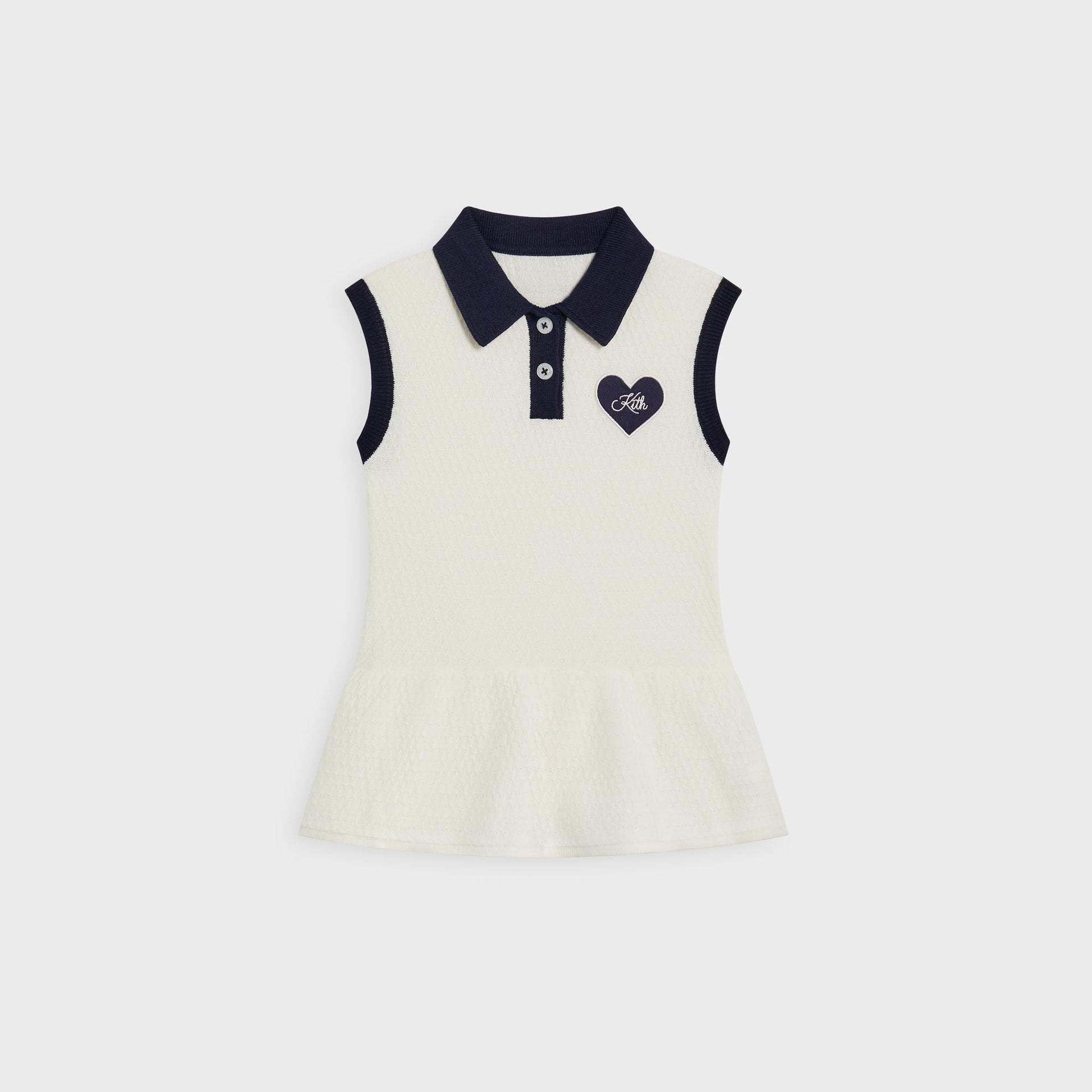 Kith Baby Knit Teagan Polo Dress in ivory, front flat lay with navy contrast collar and trim, heart Kith patch and flared peplum hem