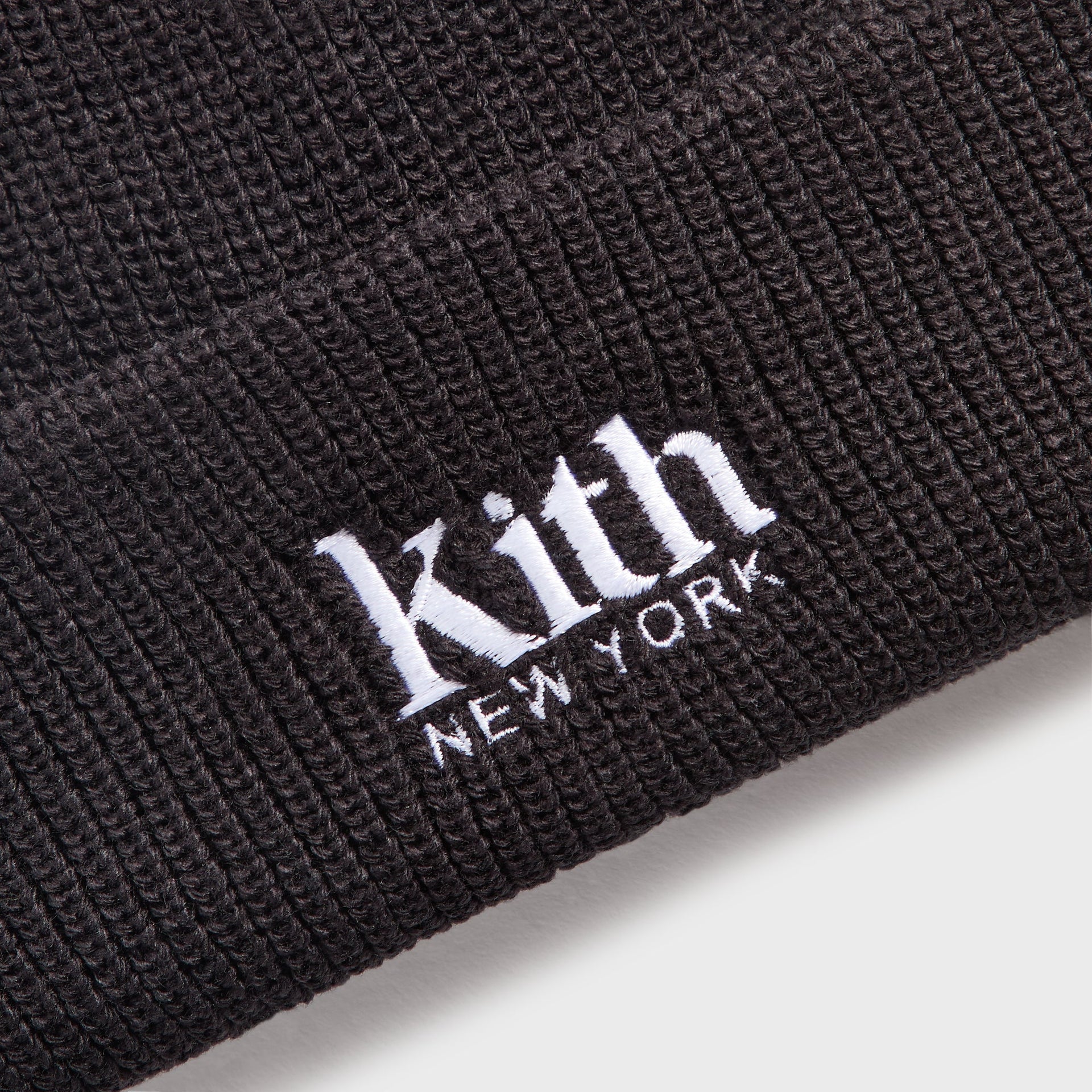 Close-up of Kith Baby Classic Beanie in black showing white Kith New York embroidered logo on ribbed cuff
