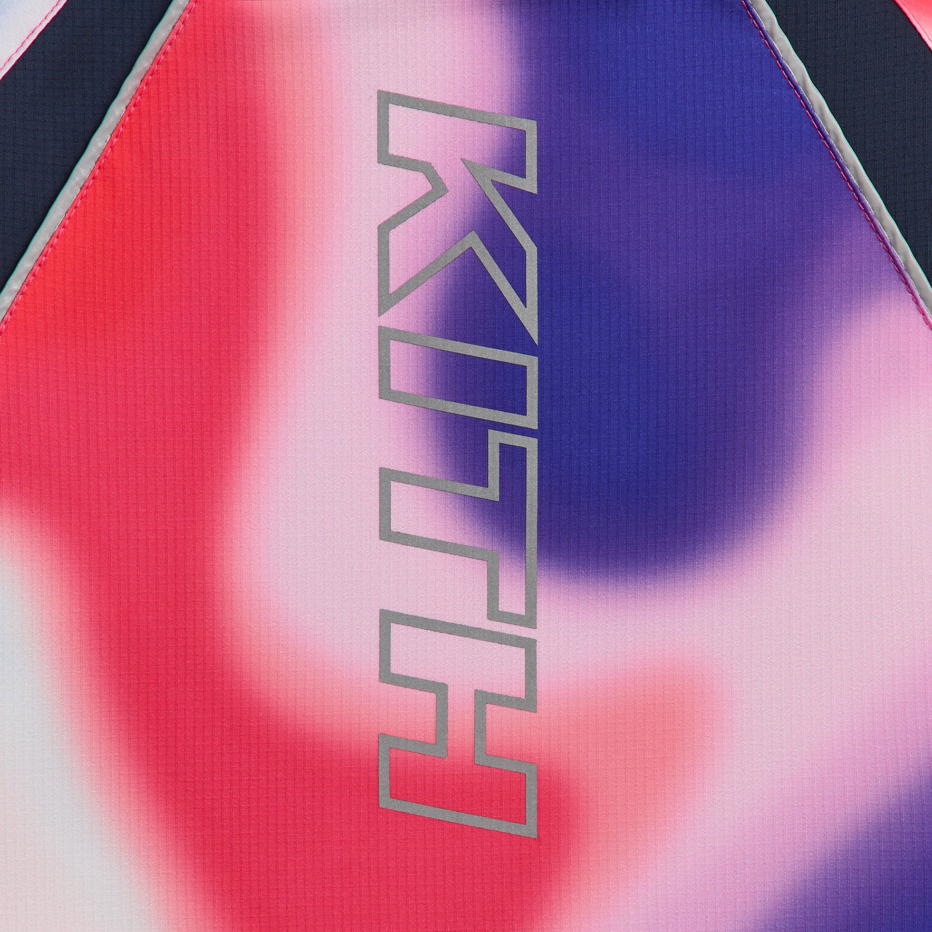 Kith Kids Lora Windbreaker close-up of reflective vertical KITH logo on Tempo swirl back panel