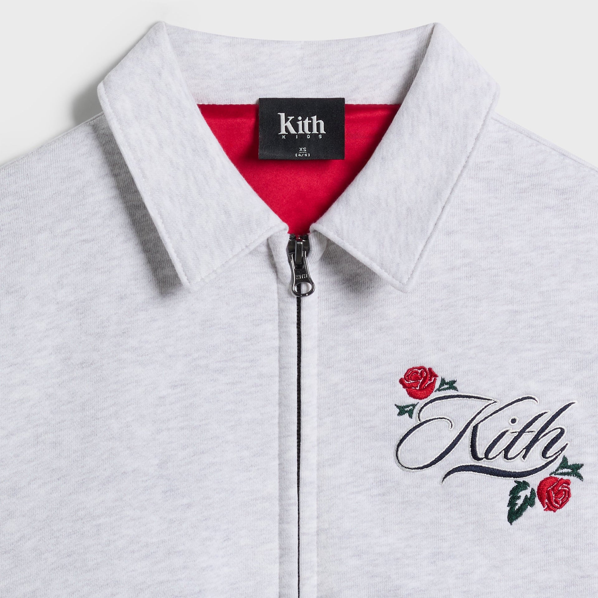 Kith Kids Wyona Fleece Bomber Jacket, close-up of collar with Kith Kids label, red lining, zip and Kith rose chest embroidery