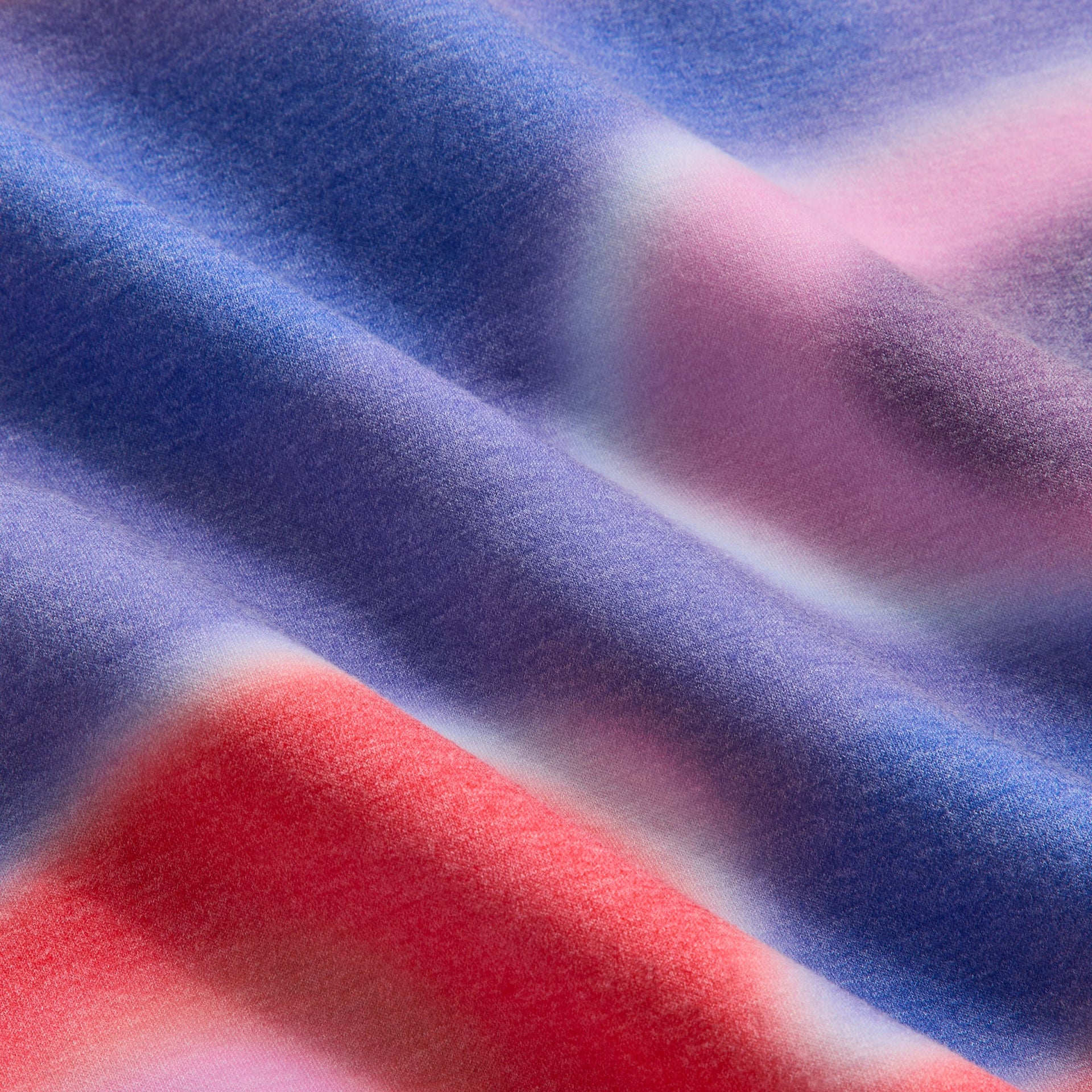 Close-up of Tempo red, blue and pink swirl print fabric on Kith Kids Adinah Quarter Zip hoodie