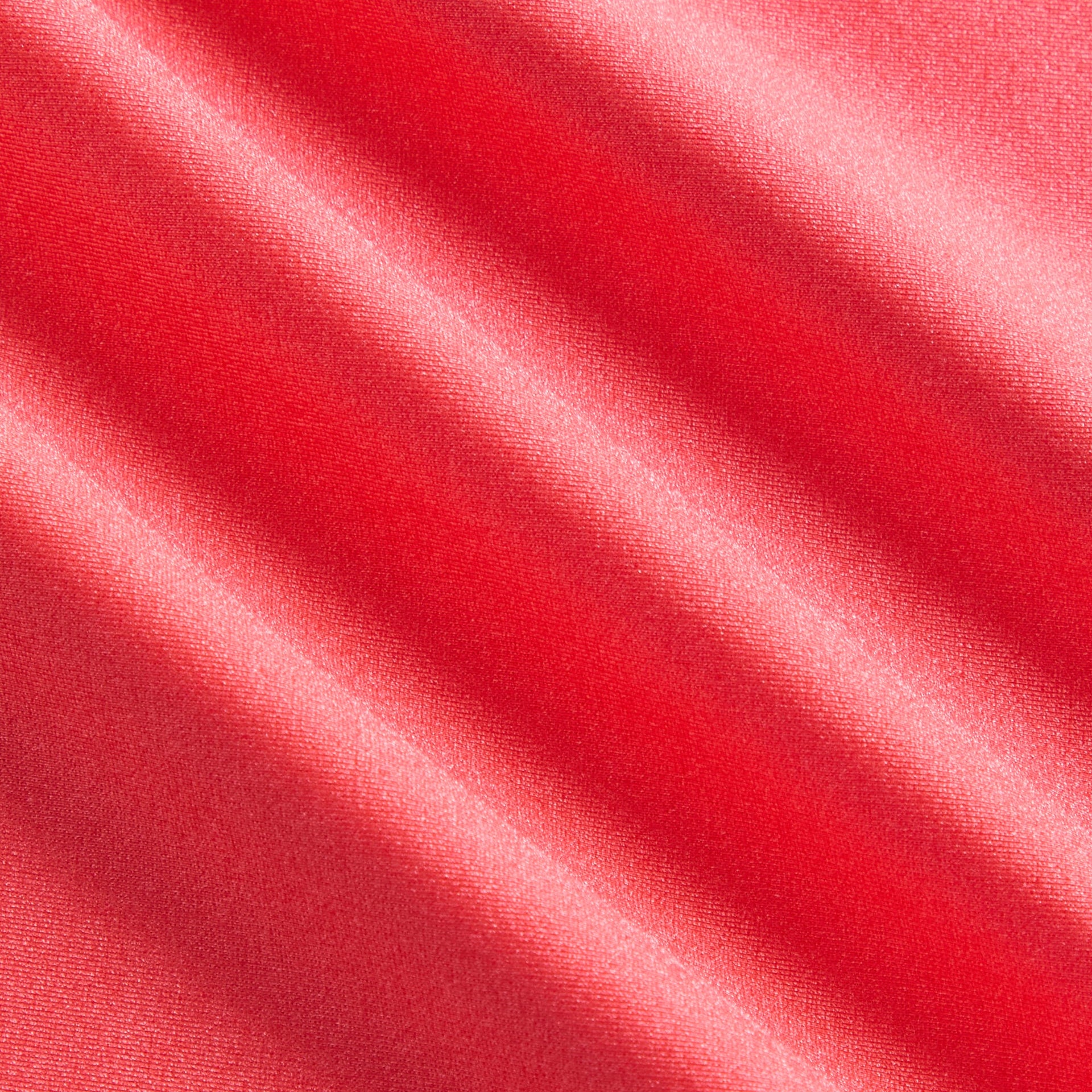 Close-up of shiny coral Carnation athletic fabric texture of Kith Kids Active Fei Cropped Tee