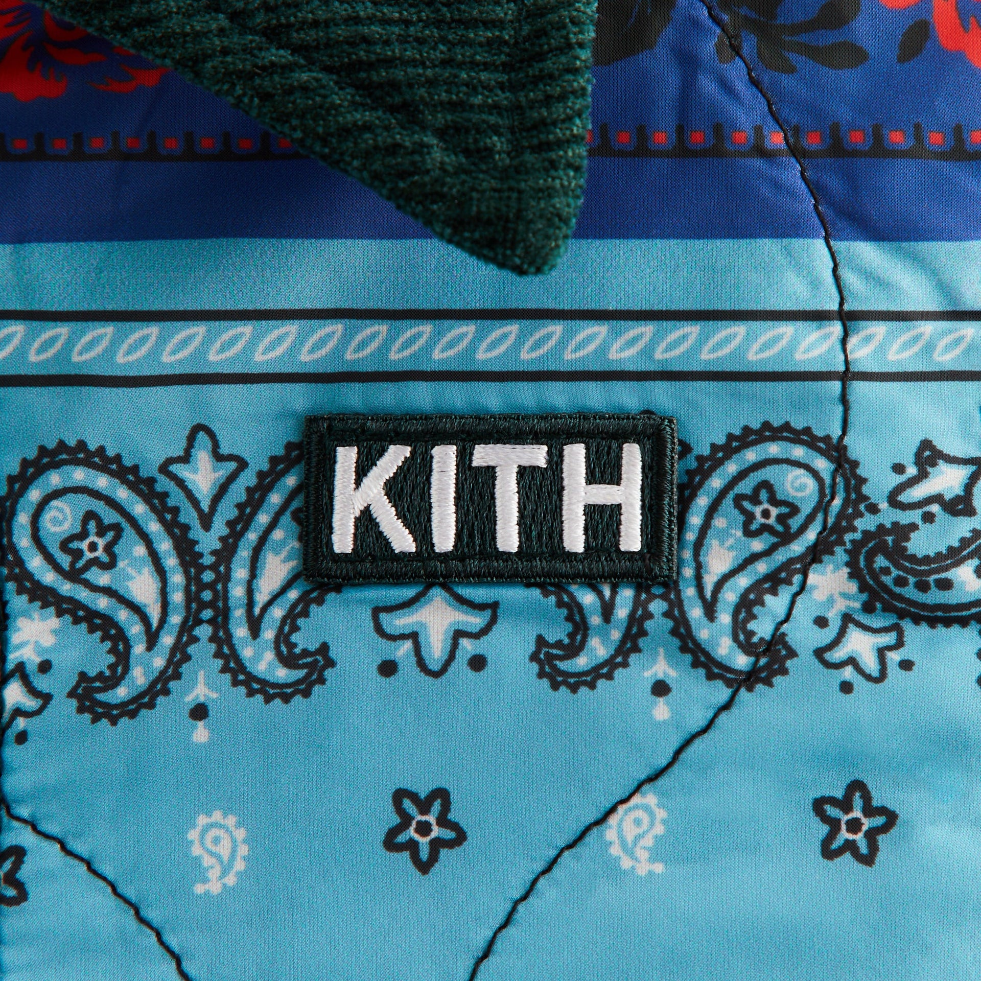 Kith Kids Reversible Ora Shacket, close-up of blue paisley bandana quilted print with white KITH patch