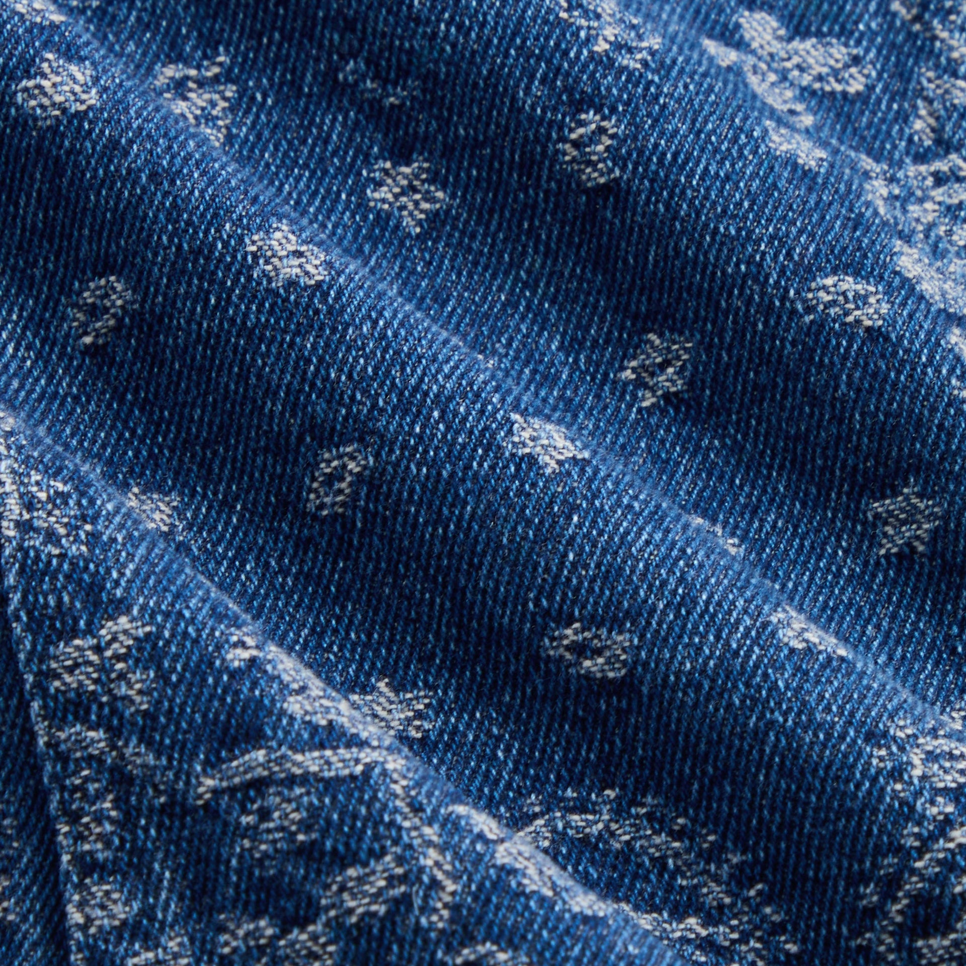 Close-up of Medium Indigo denim with laser paisley bandana print on Kith Kids Ginza Shirt