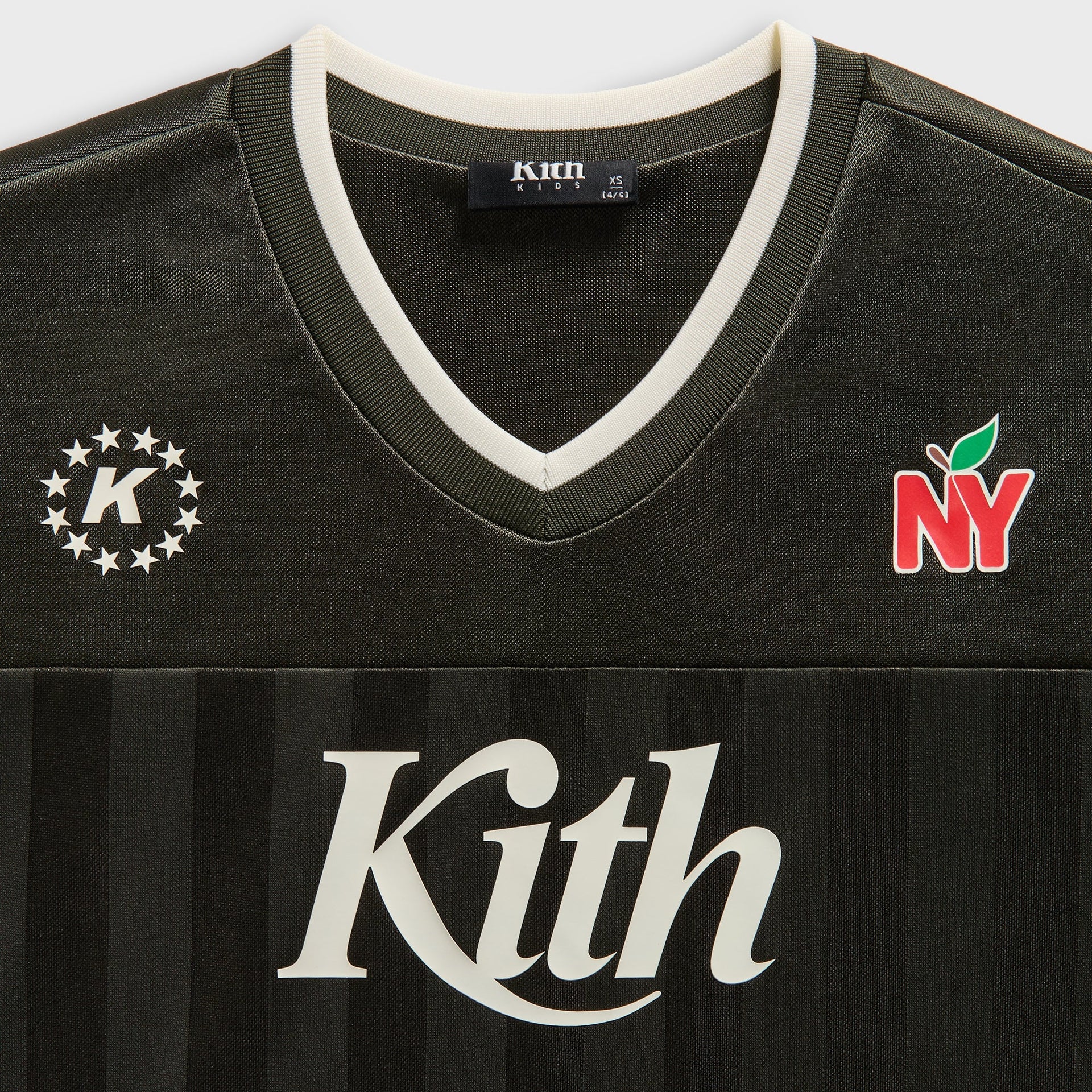 Kith Kids Malik Jersey, close-up of cream-trimmed V-neck with star K crest and NY apple logo