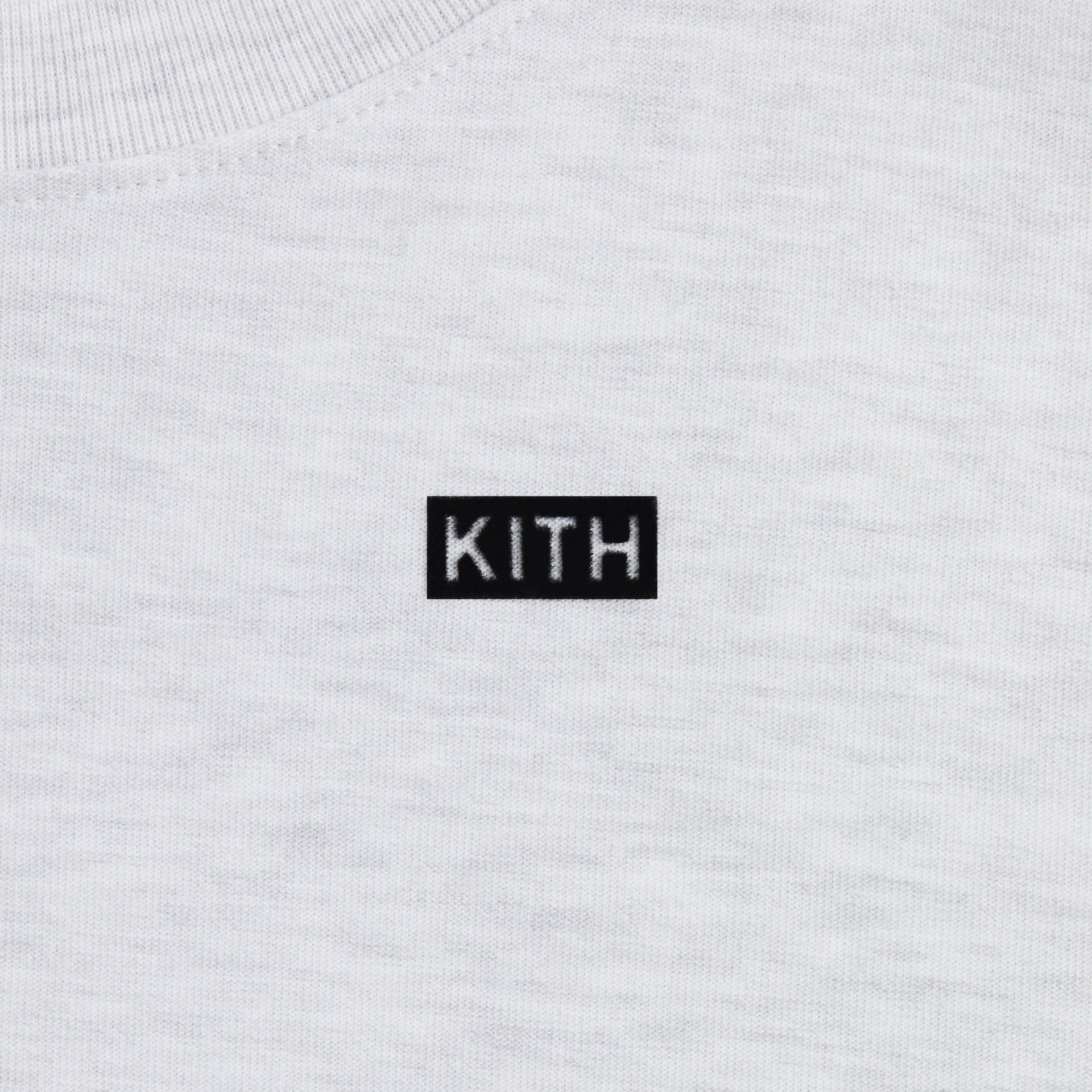 Close-up of black KITH box logo embroidery on light heather grey long sleeve tee