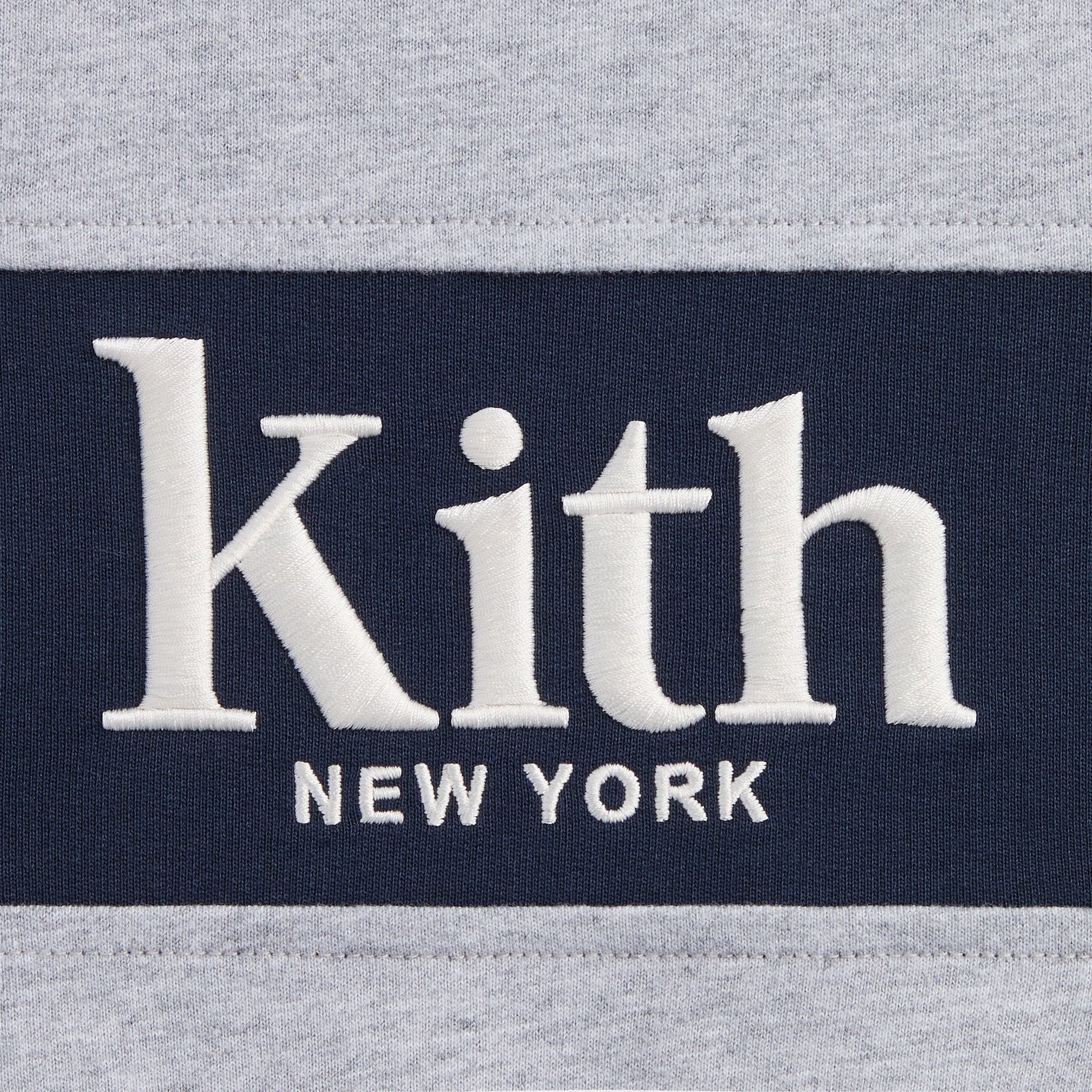Kith Kids Tatyana Cropped Pullover in Medium Heather Grey, close-up of navy chest panel with embroidered white Kith New York logo