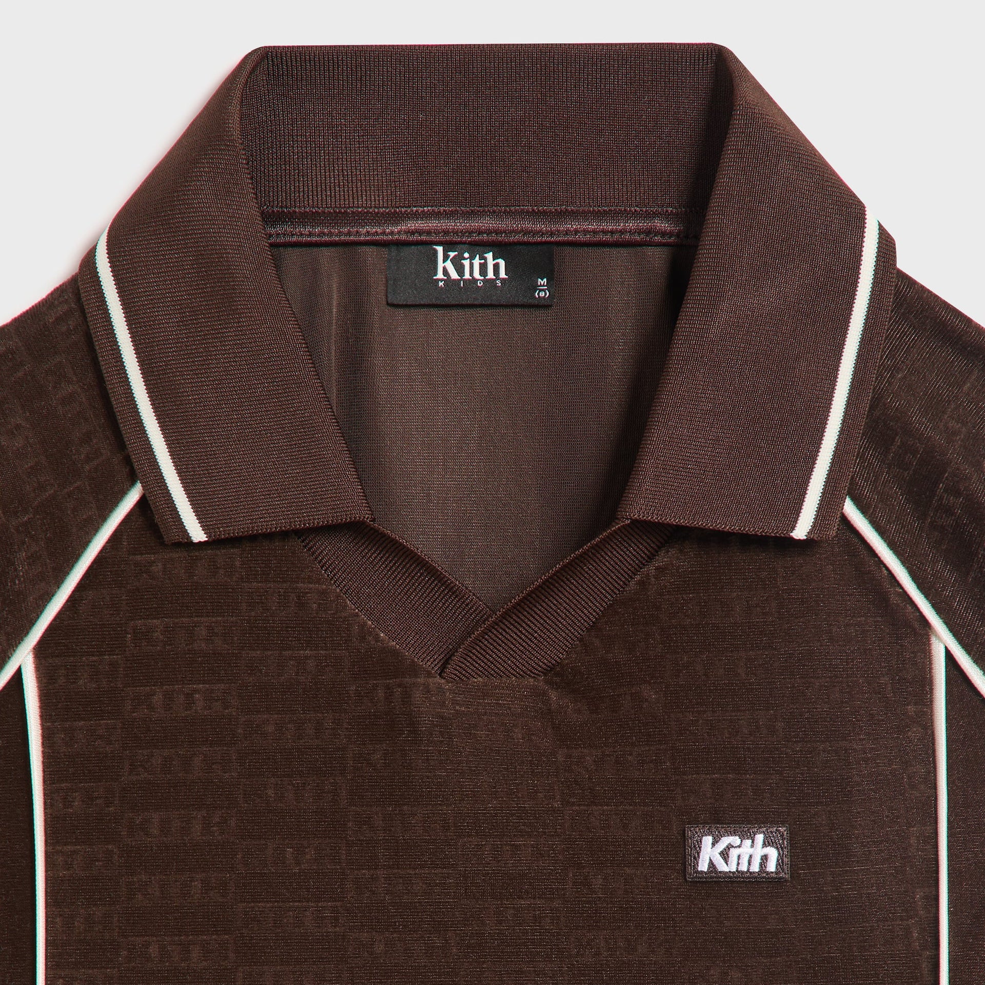 Kith Kids Monogram Velour Soccer Jersey close-up of open collar, cream tipping and Kith chest patch