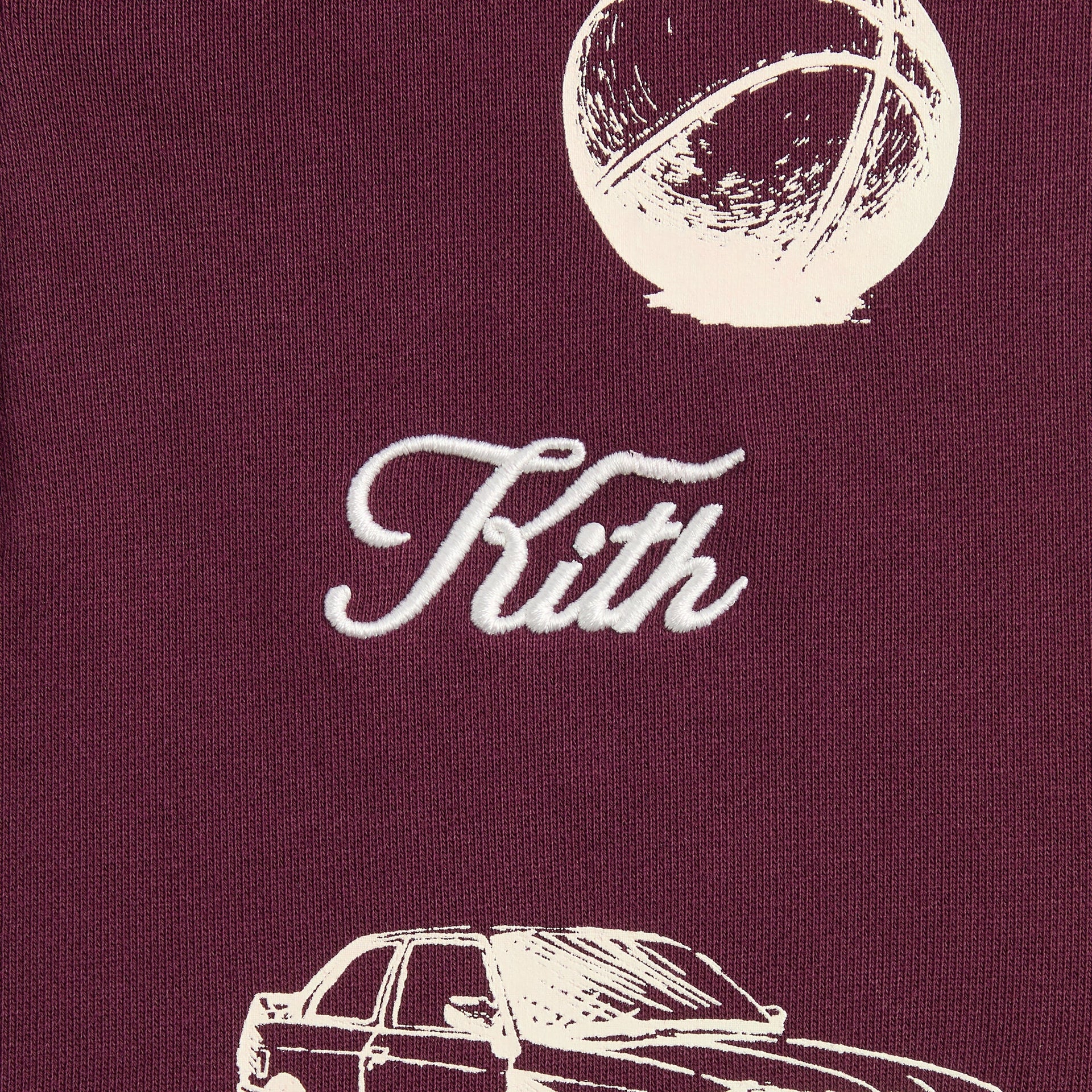 Kith Kids Hunter Pullover close-up of cream Kith cursive embroidery, basketball and car sketches