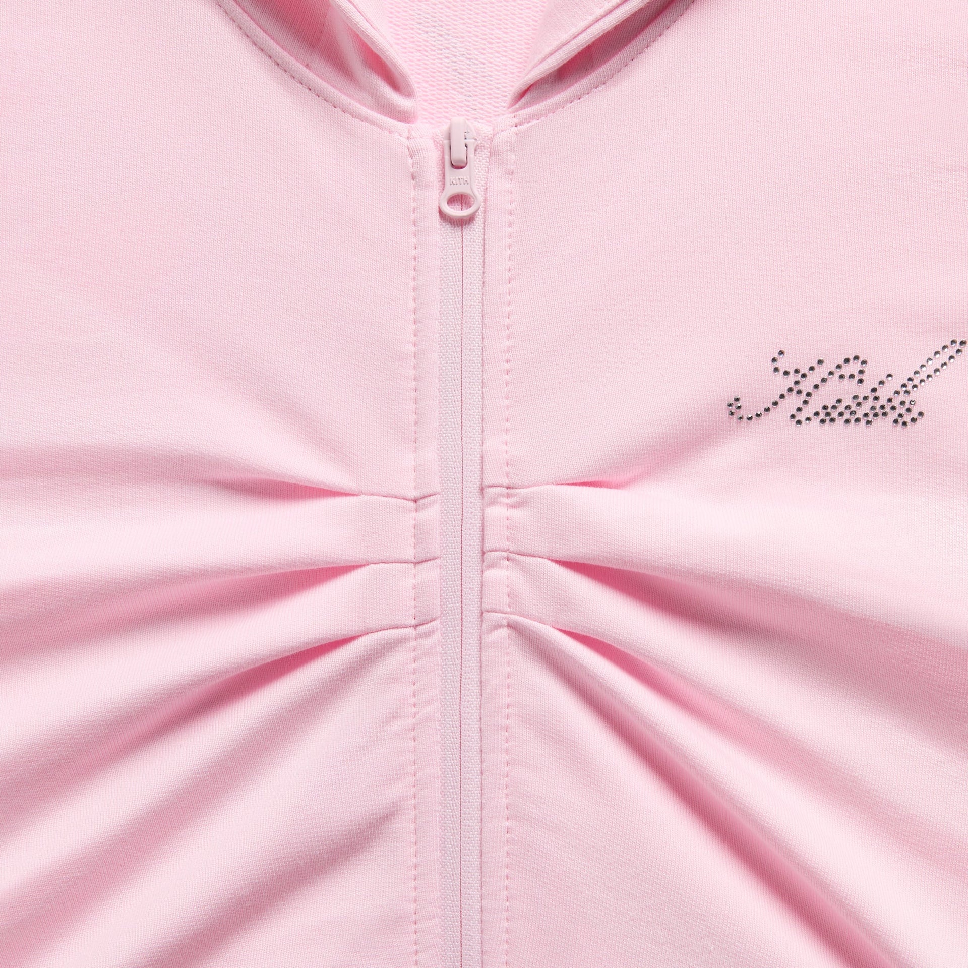 Close-up of front zipper, ruched center gathering and rhinestone Kith script on pink Cropped Nelson Hoodie