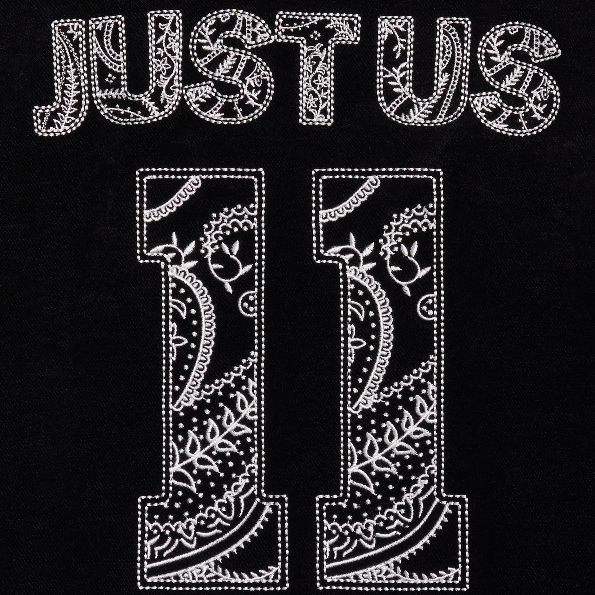 Close-up of the paisley-filled JUST US 11 lettering on the back of the black Kith Kids Nelson sweatshirt