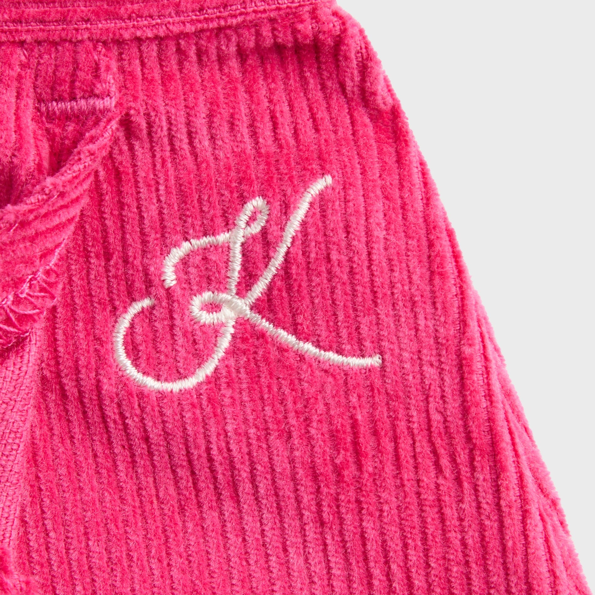 Close-up of white cursive K embroidery on hot pink Zinnia corduroy Kith Kids Jessie Cord Skirt