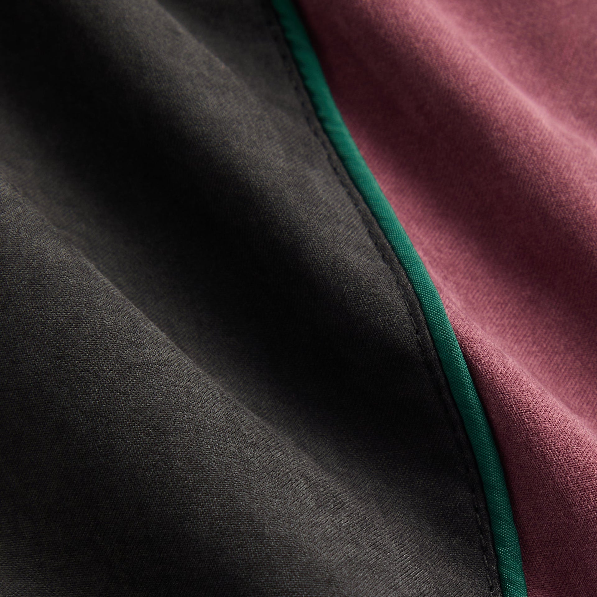 Kith Kids Milo II Track Pant in black, close-up of green piping between black and maroon panels