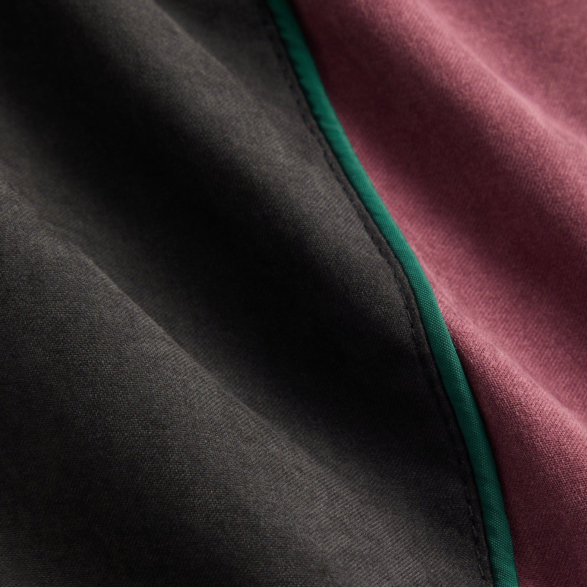 Kith Kids Blocked Track Skirt in Black, macro detail of black, burgundy and green piped color-block seam