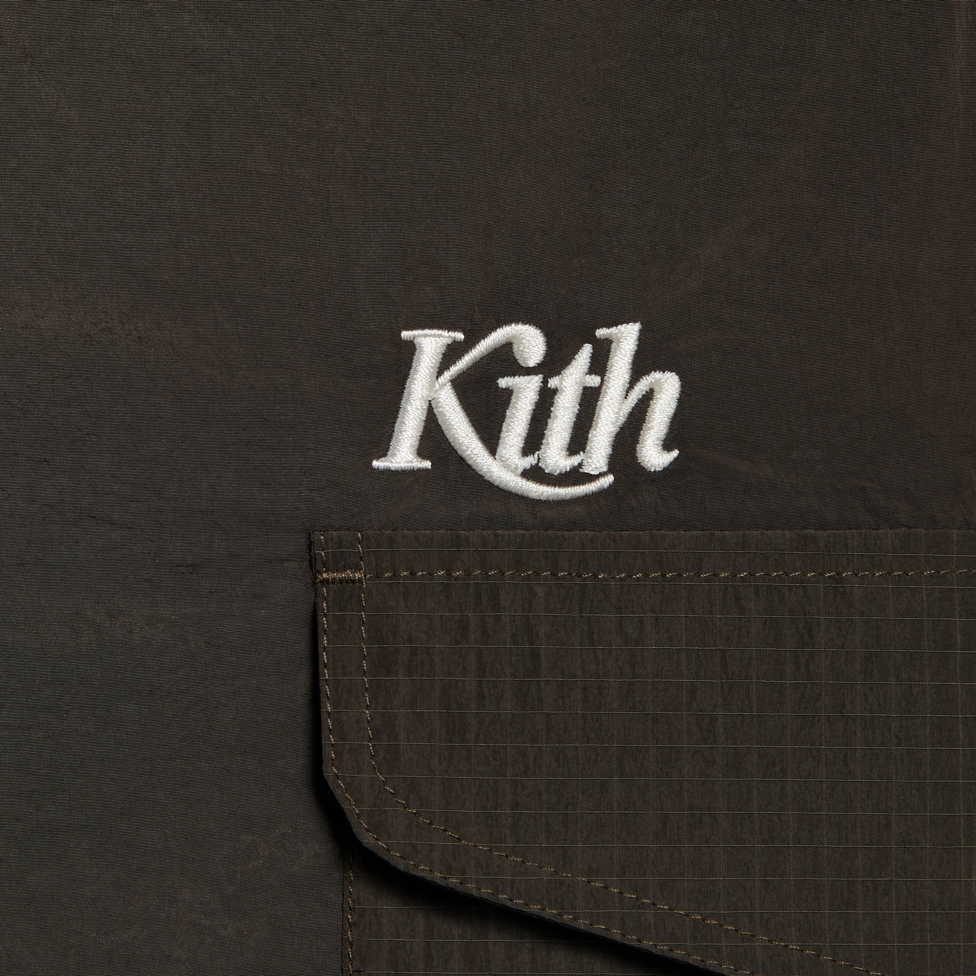 Kith Kids Kaiden Pant in Monarch brown, close-up of white Kith script logo and ripstop cargo pocket