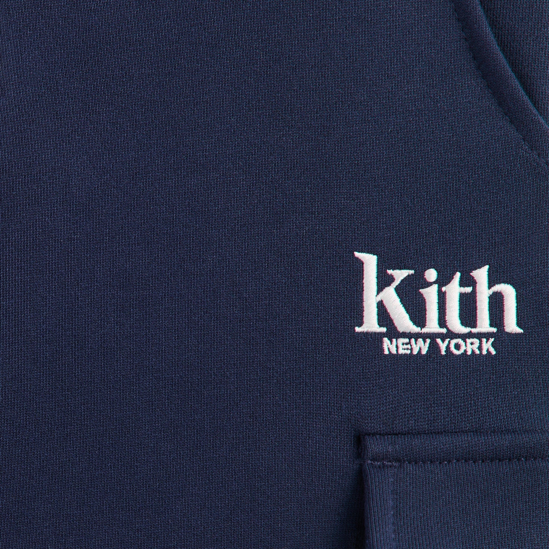 Kith Kids Williams Cargo Sweatpant close-up of white Kith New York embroidery on navy fleece