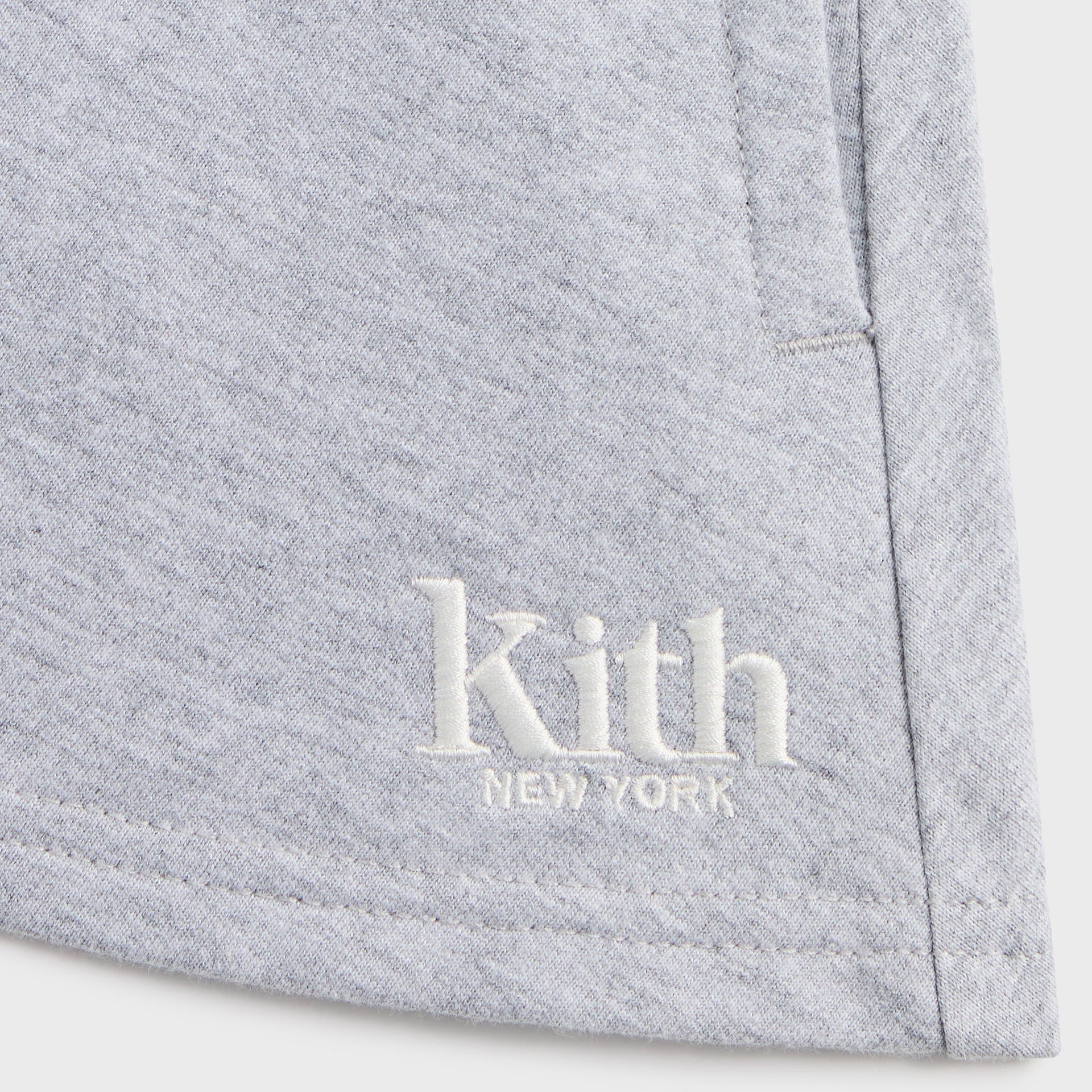 Kith Kids Logo Riley II Skort in heather grey, close-up of embroidered white Kith New York logo at hem