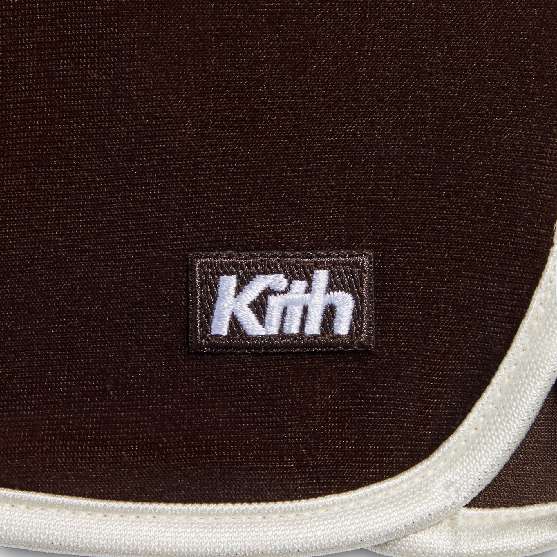 Kith Kids Monogram Velour Jordan Short in brown Kindling, close-up of white Kith woven label and cream piping