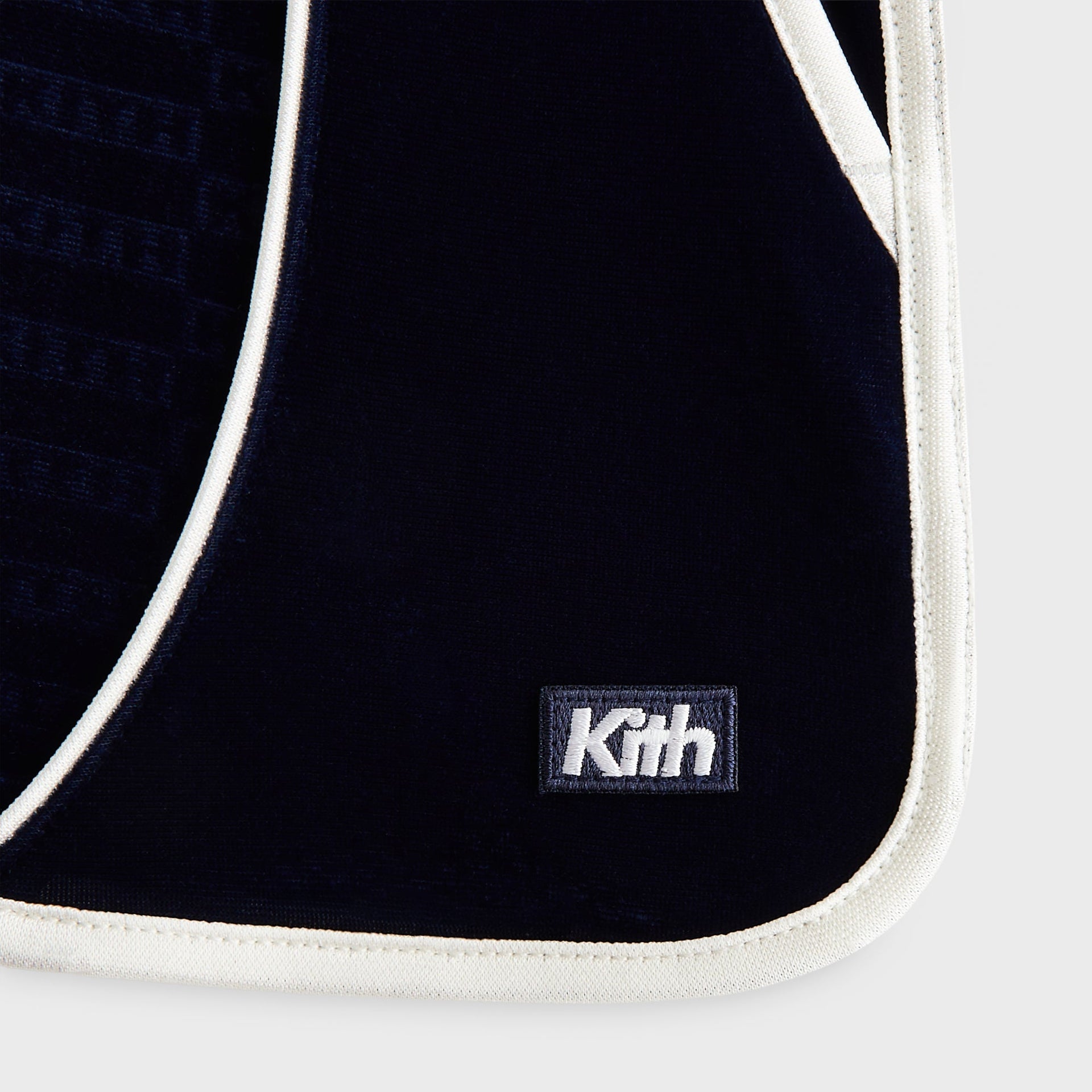 Kith Kids Monogram Velour Jordan Short in navy nocturnal, close-up of embroidered Kith box logo and white piping