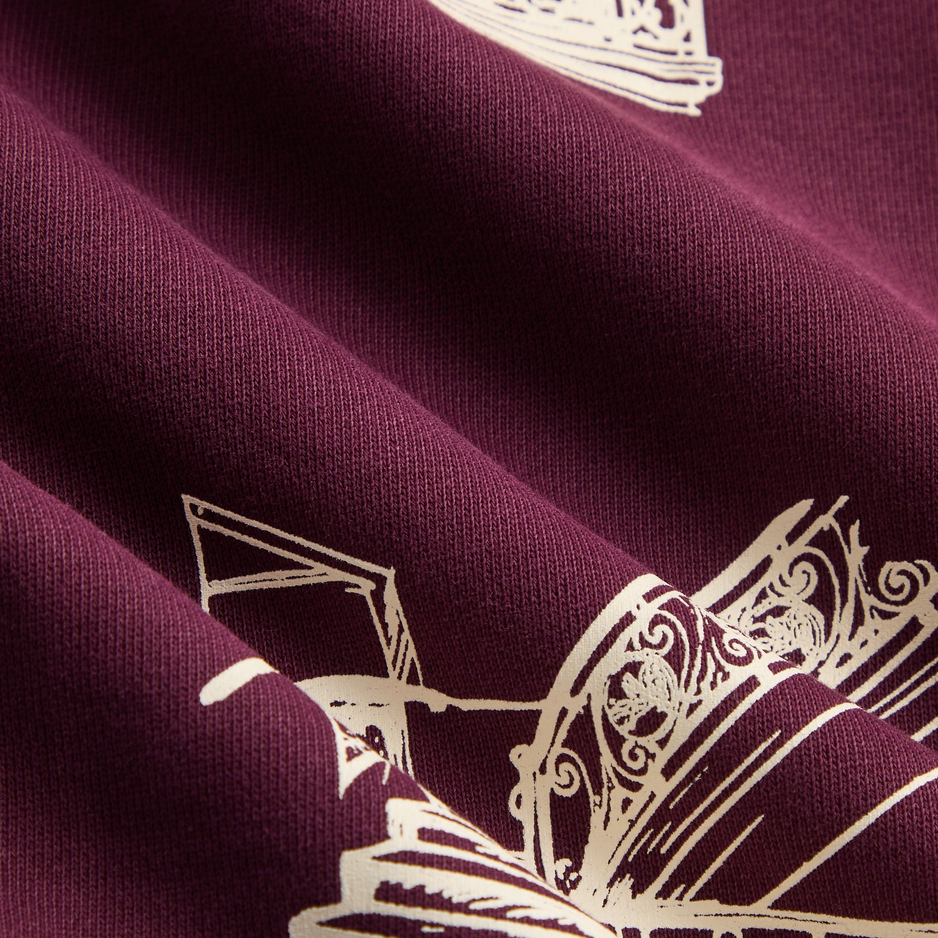 Kith Kids Logo Nelson Short in burgundy essence, macro close-up of fleece fabric with cream illustrations