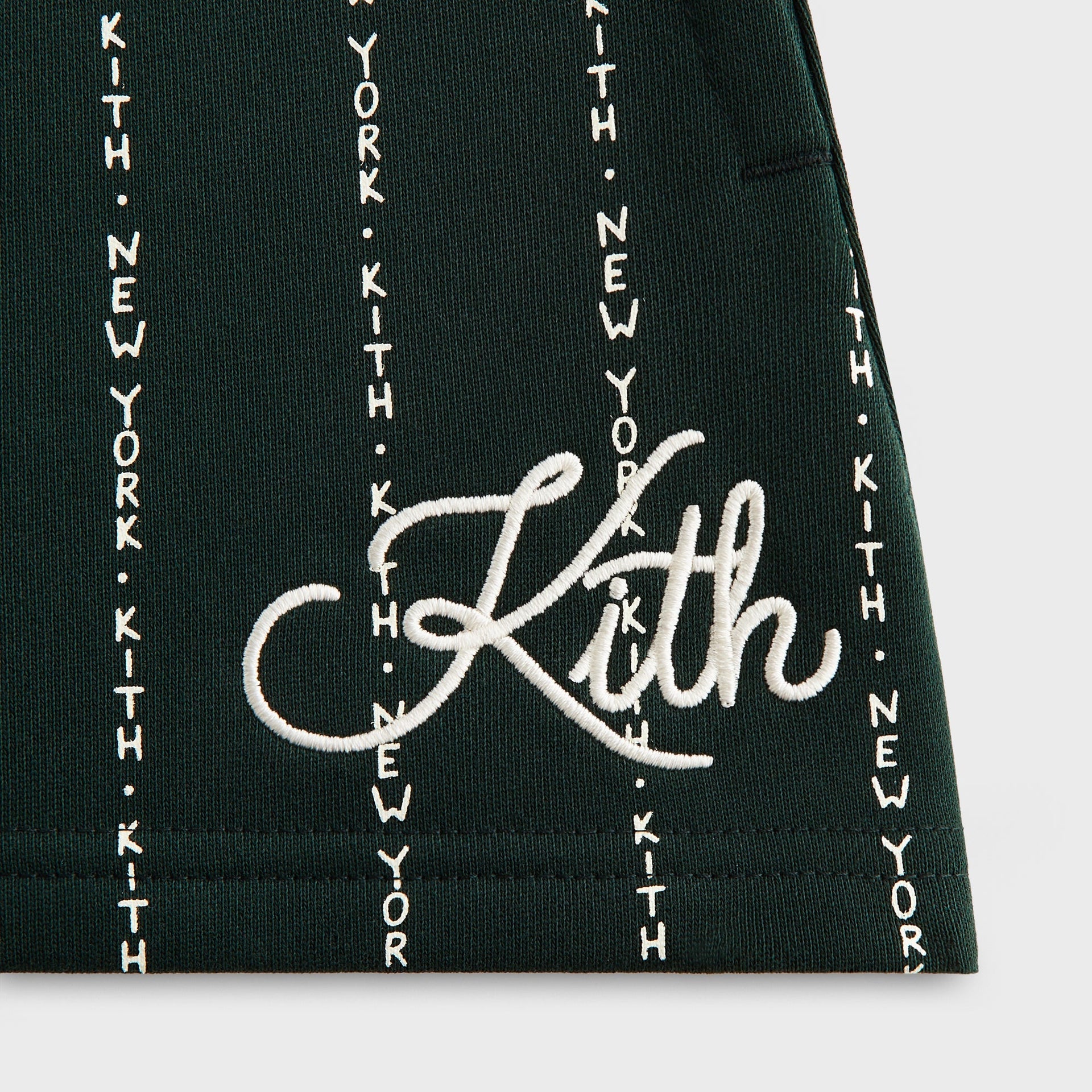 Close-up of white cursive Kith embroidery on green KITH New York pinstripe Kith Kids Liam Short