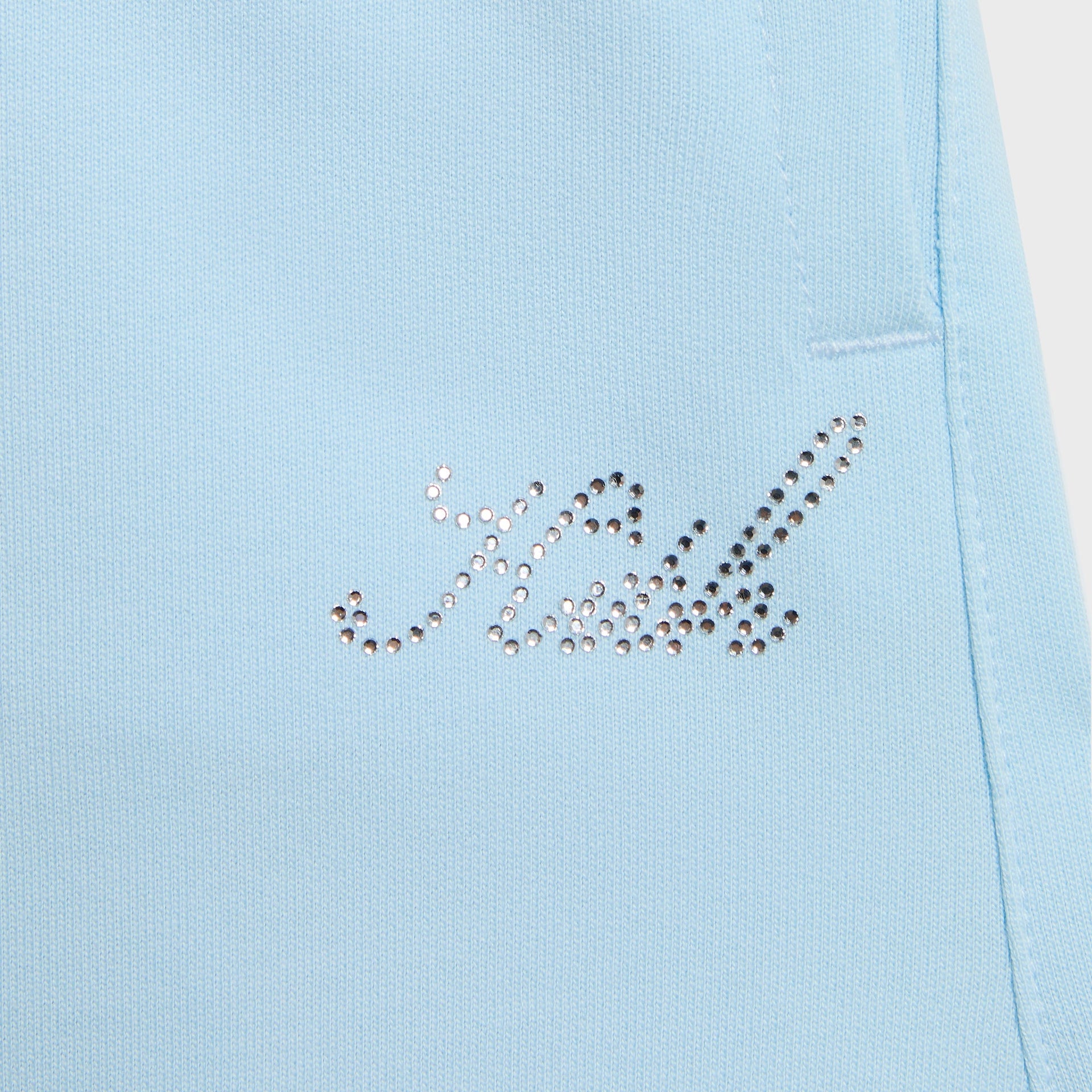 Kith Kids Ava Sweatpant in light blue, close-up of small rhinestone Kith script logo at hip