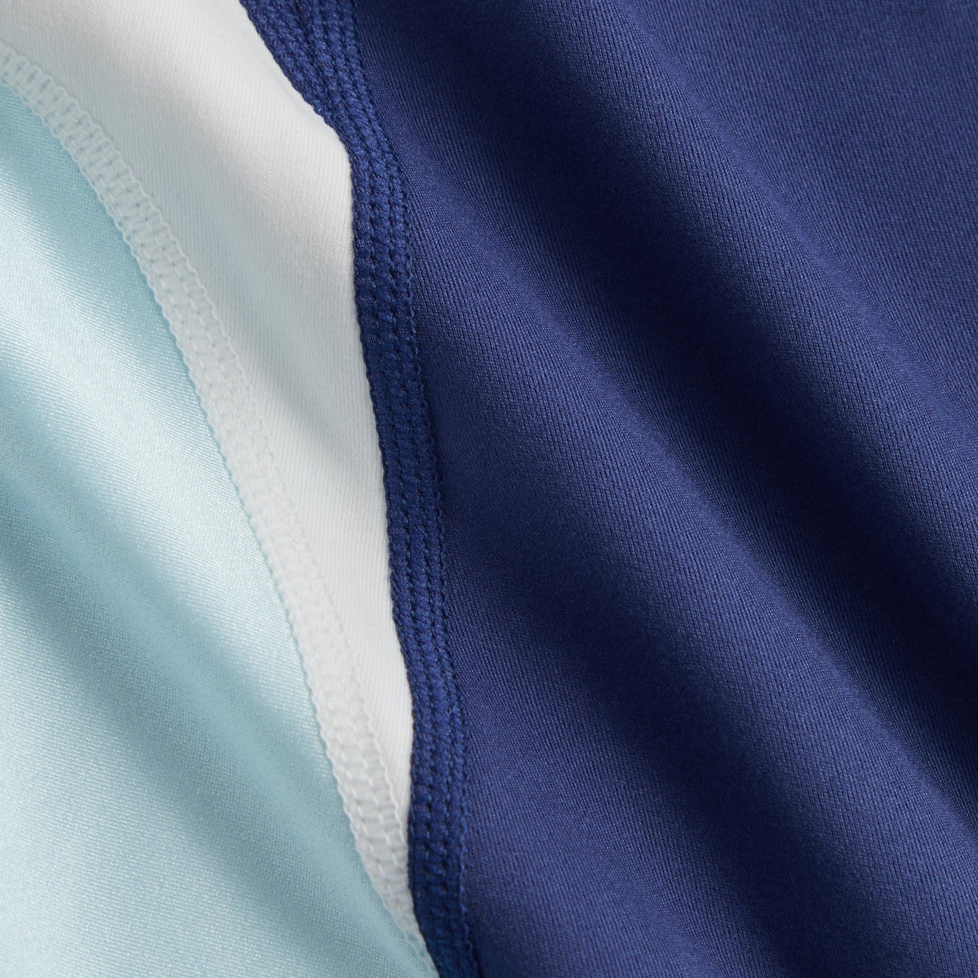 Kith Kids Active Skye Romper Dress in Nocturnal, macro detail of navy, white and light blue color-blocked fabric seam