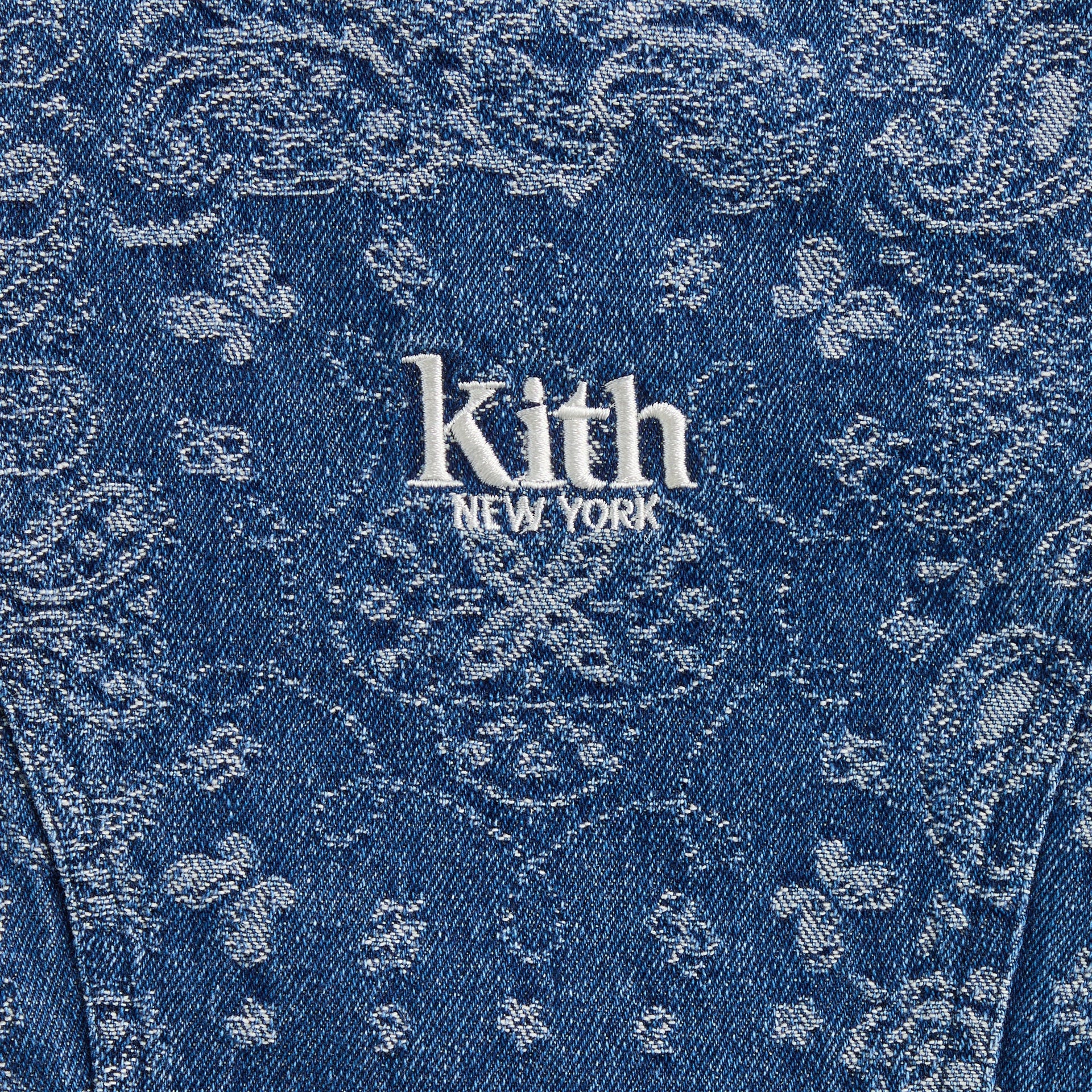 Close-up of white embroidered Kith New York logo on indigo paisley denim Gabrielle Dress