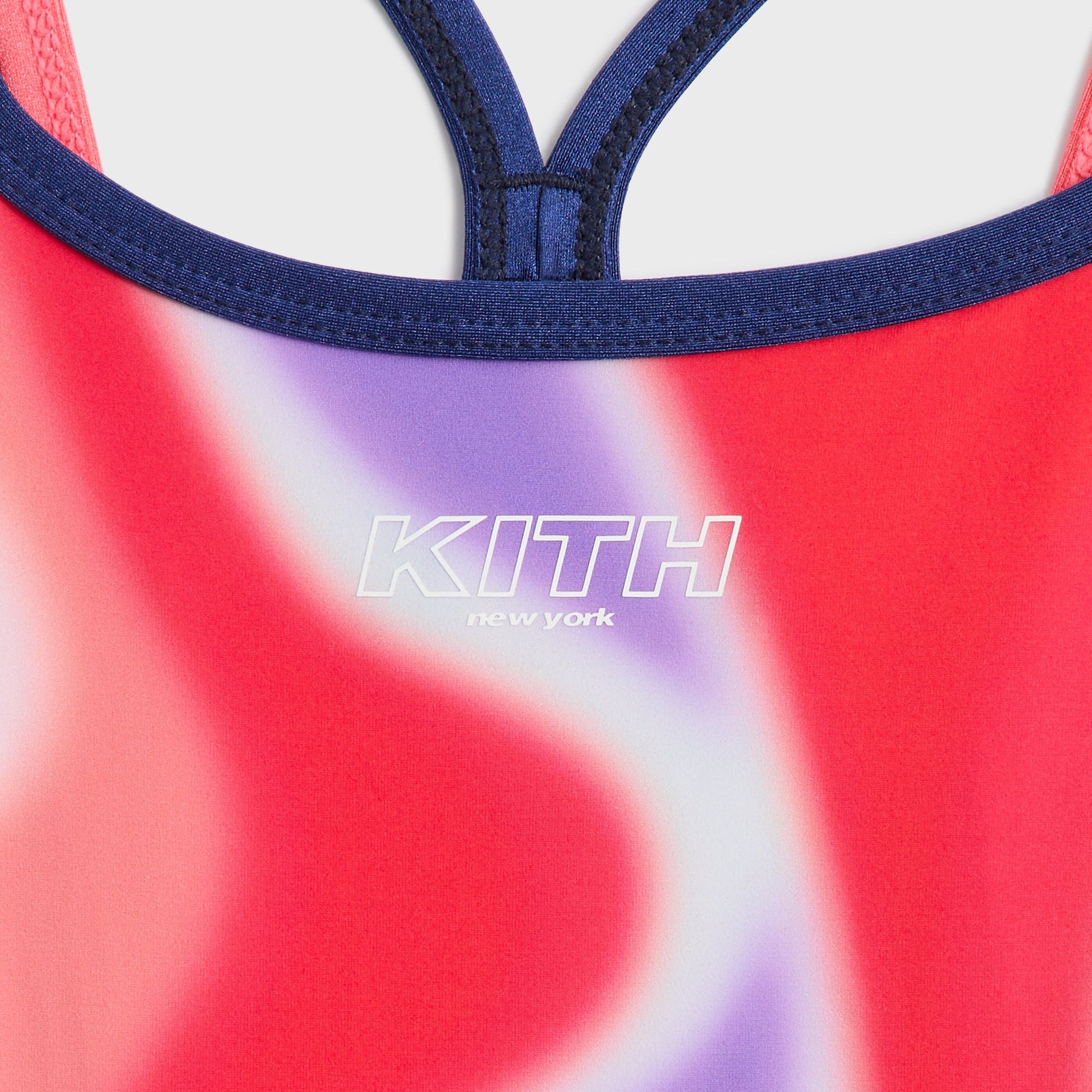 Kith Kids Remi Romper close-up of KITH New York chest logo and navy racerback straps