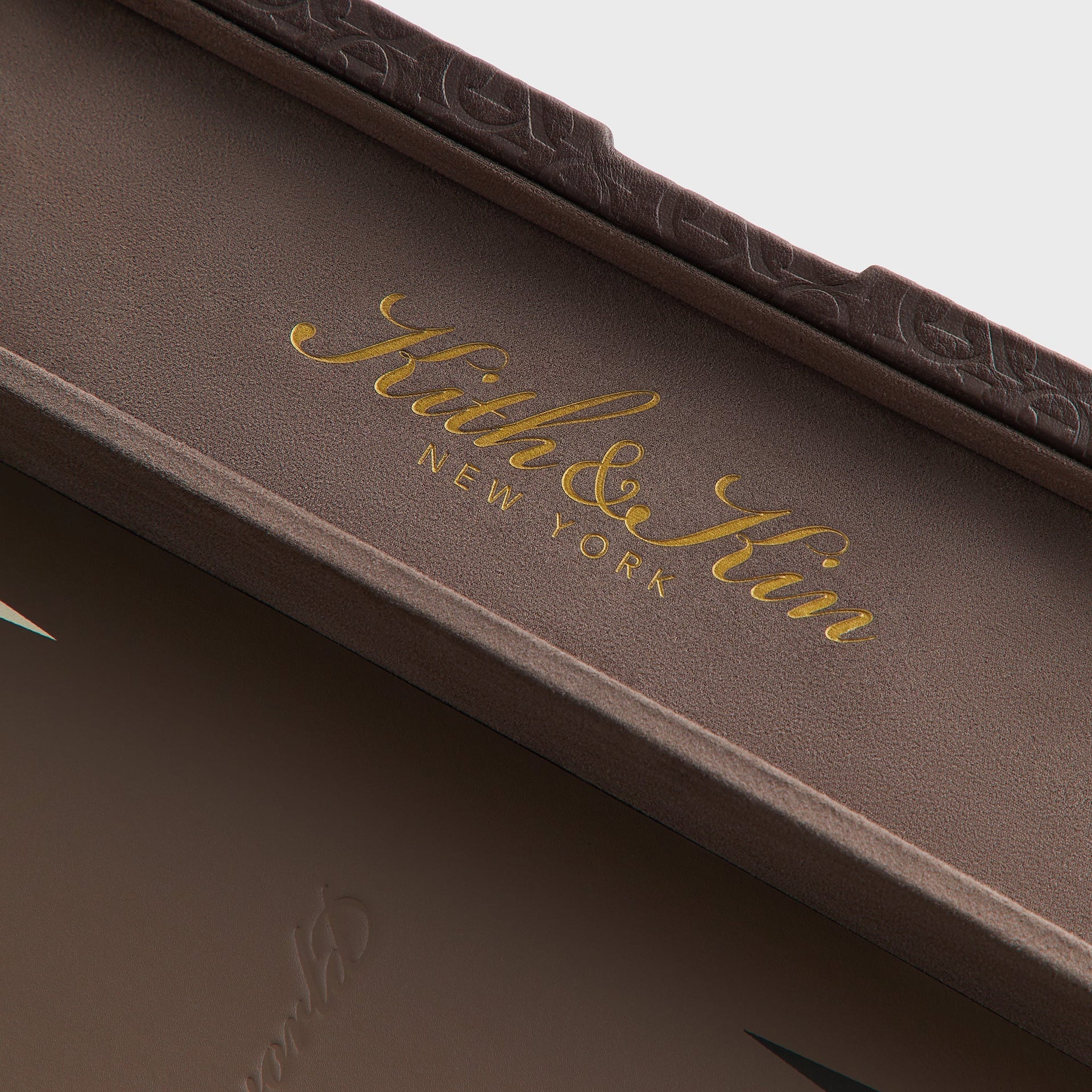 Detail of the Kith & Kin New York gold foil branding on the suede-lined interior lid of the backgammon case