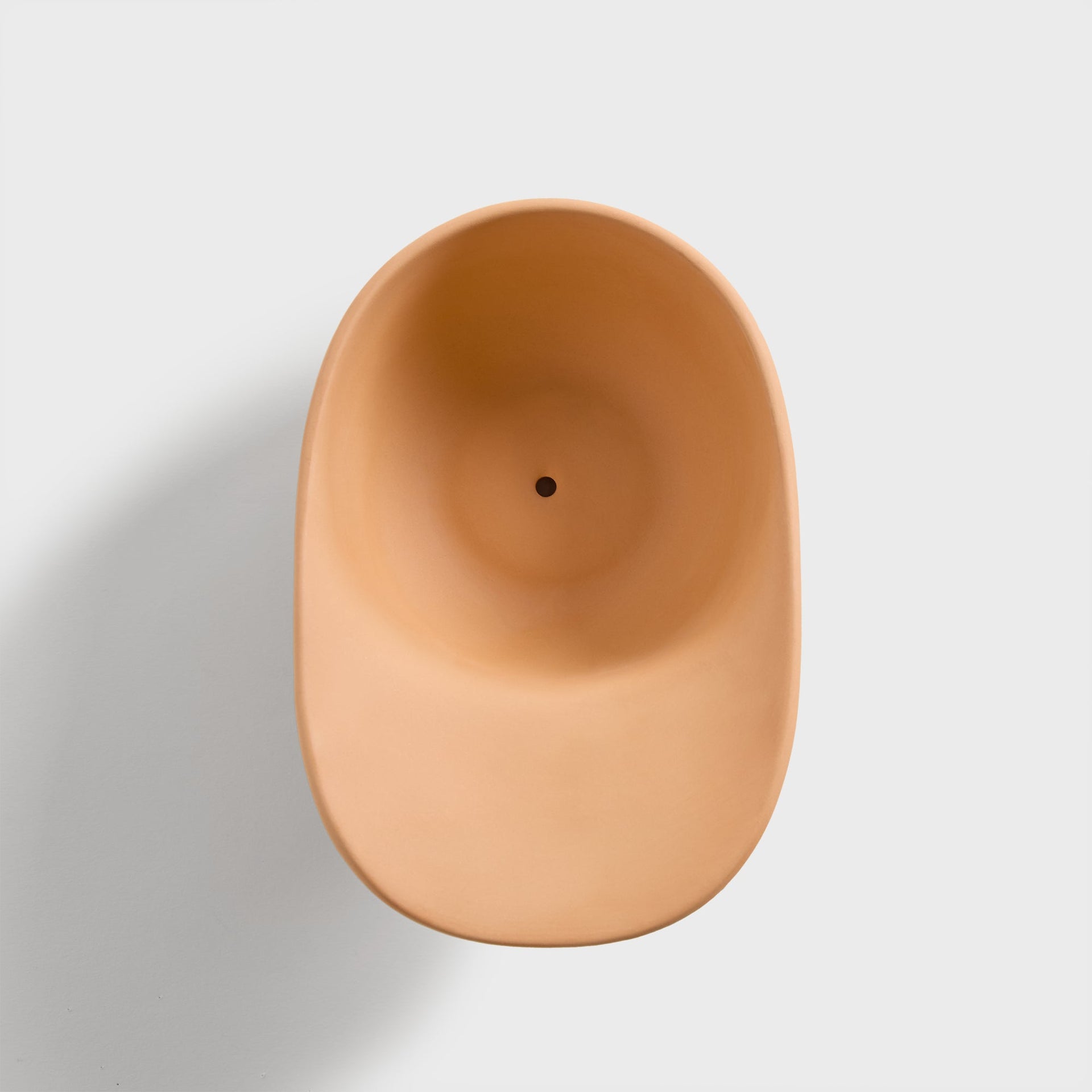 Top-down view of the terracotta cap planter showing the oval opening and drainage hole