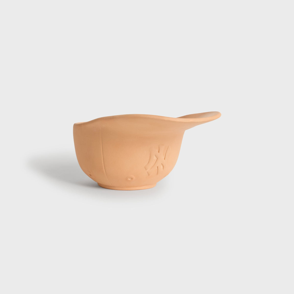 Three-quarter side view of the Kith x Yankees terracotta cap planter highlighting the curved brim