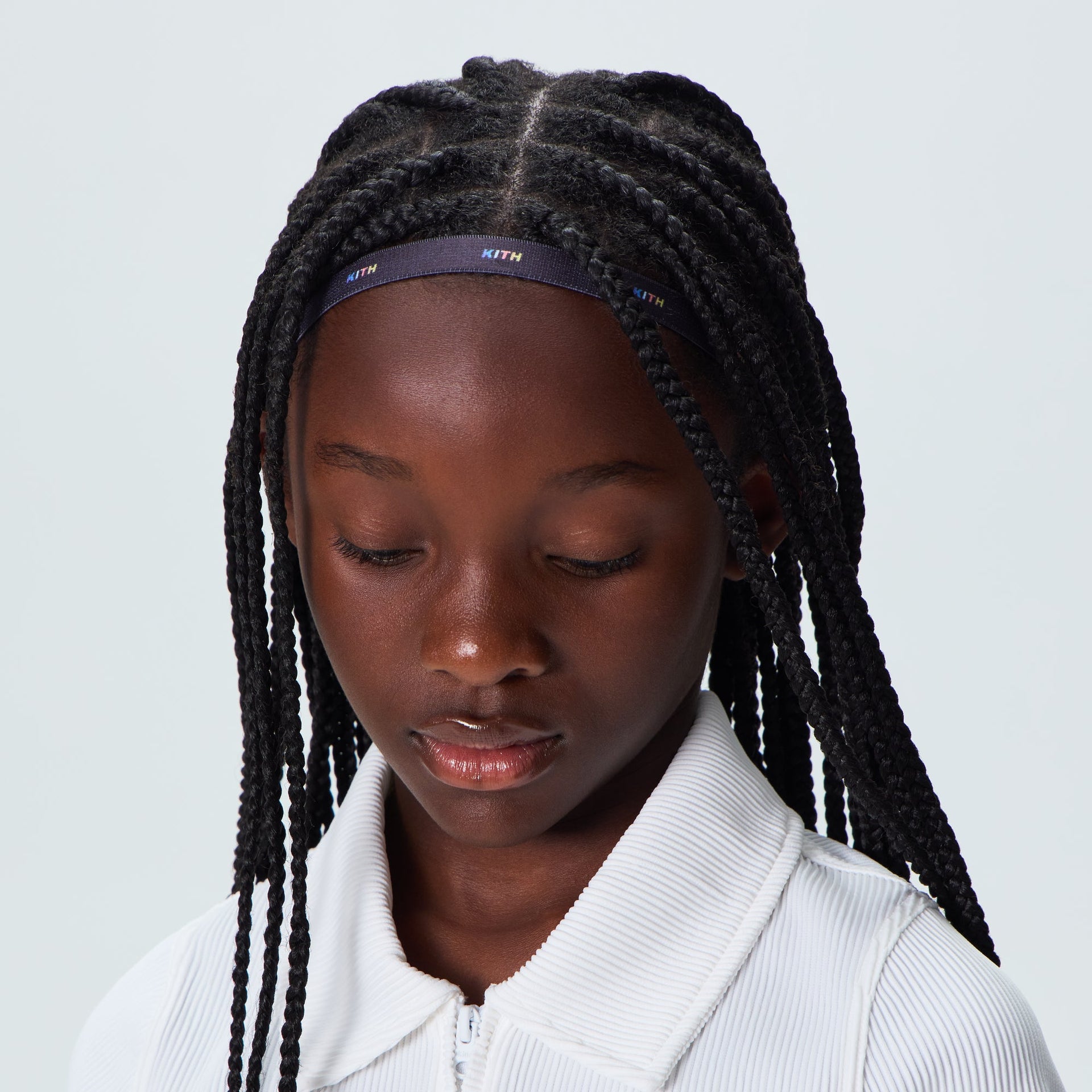 Kith Kids Printed Headband in black with rainbow logo, worn by child, front view