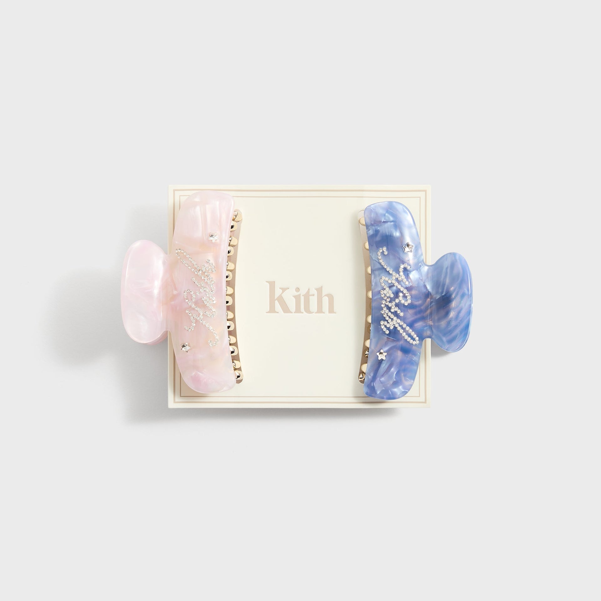 Kith Kids Set of 2 Rhinestone Hair Clips, pink and blue marble clips displayed on cream Kith card
