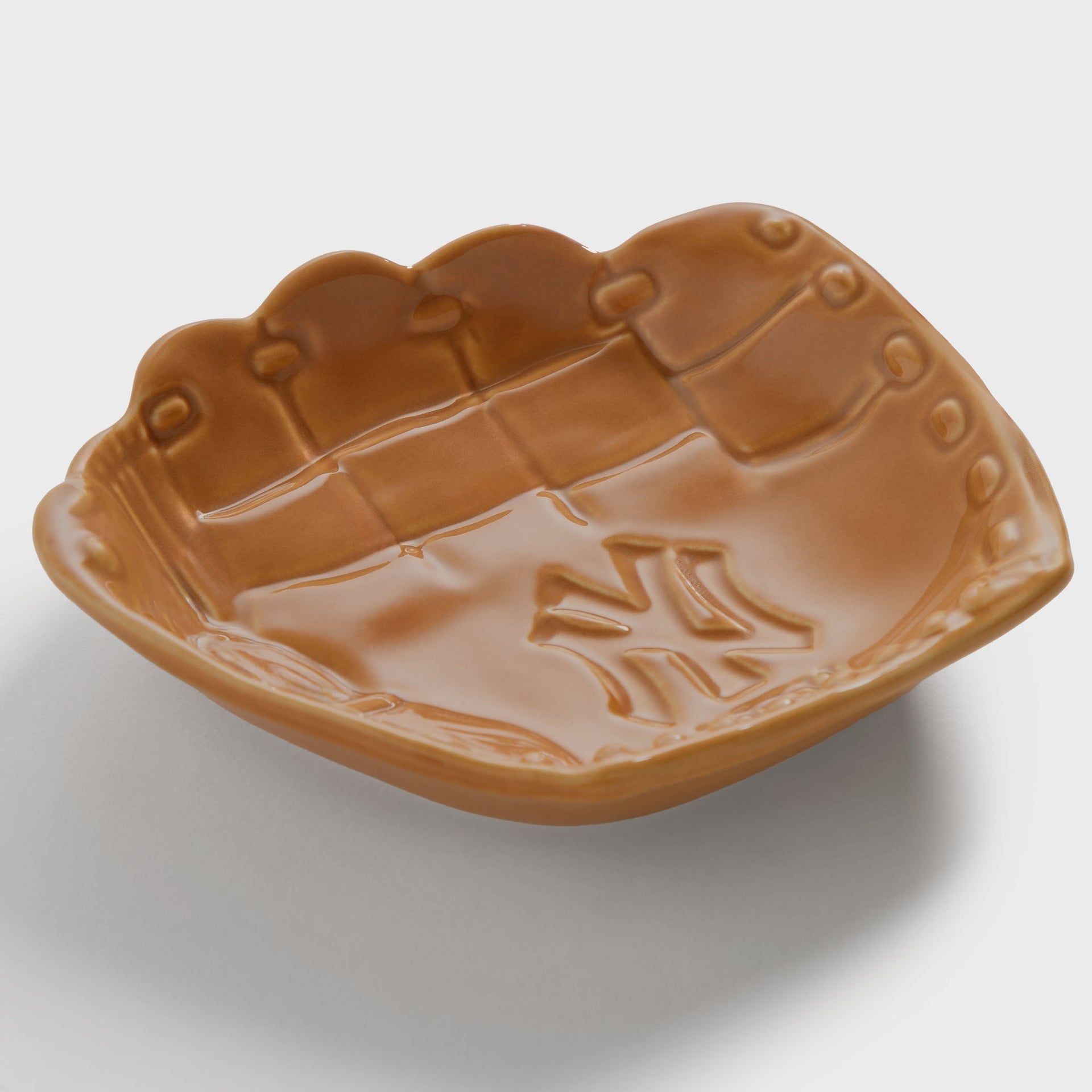 Kith x Yankees Baseball Glove Catchall Tray in tan - angled view showing stitched-leather texture and glove webbing detail