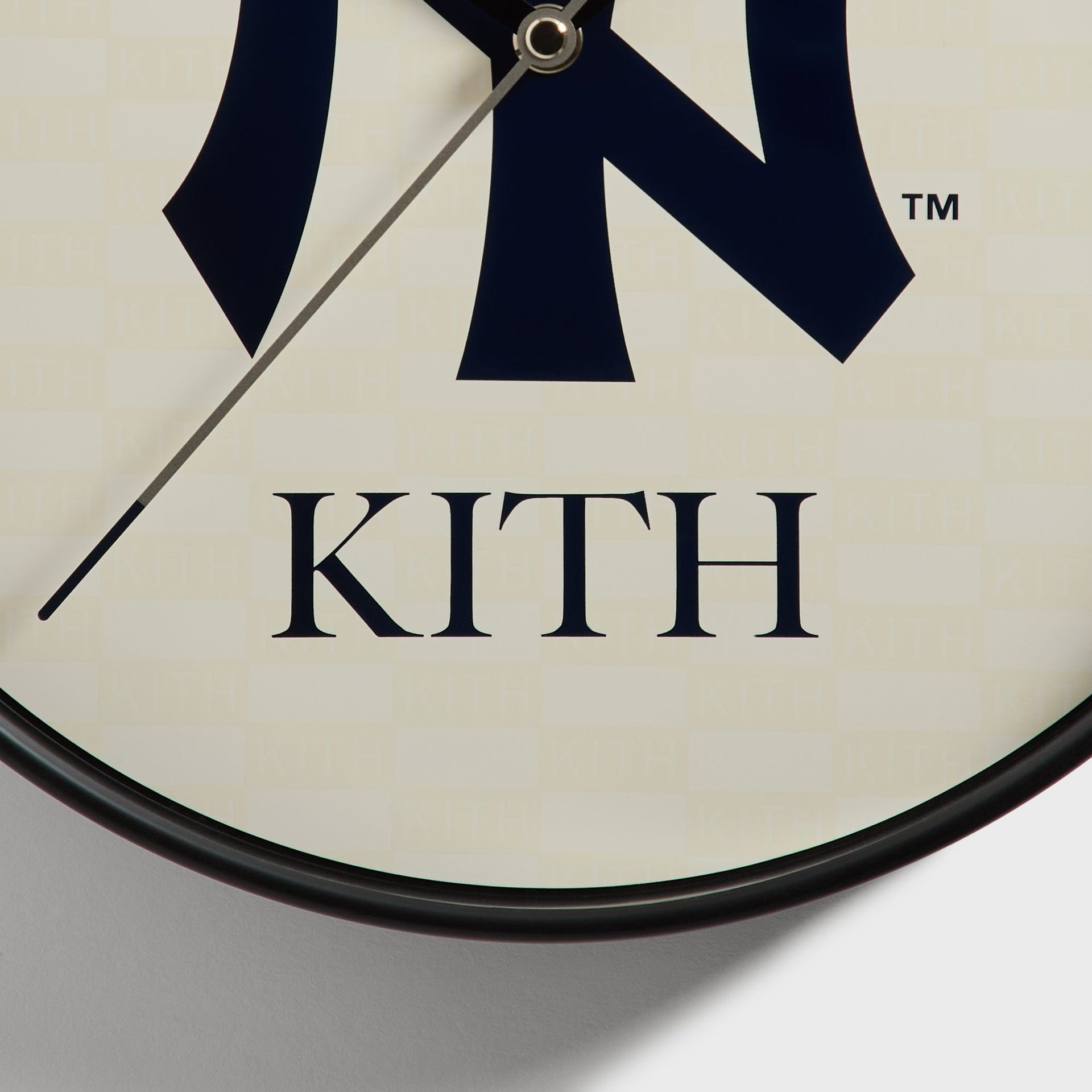 Close-up of Kith wordmark and clock hands on the lower face of the wall clock