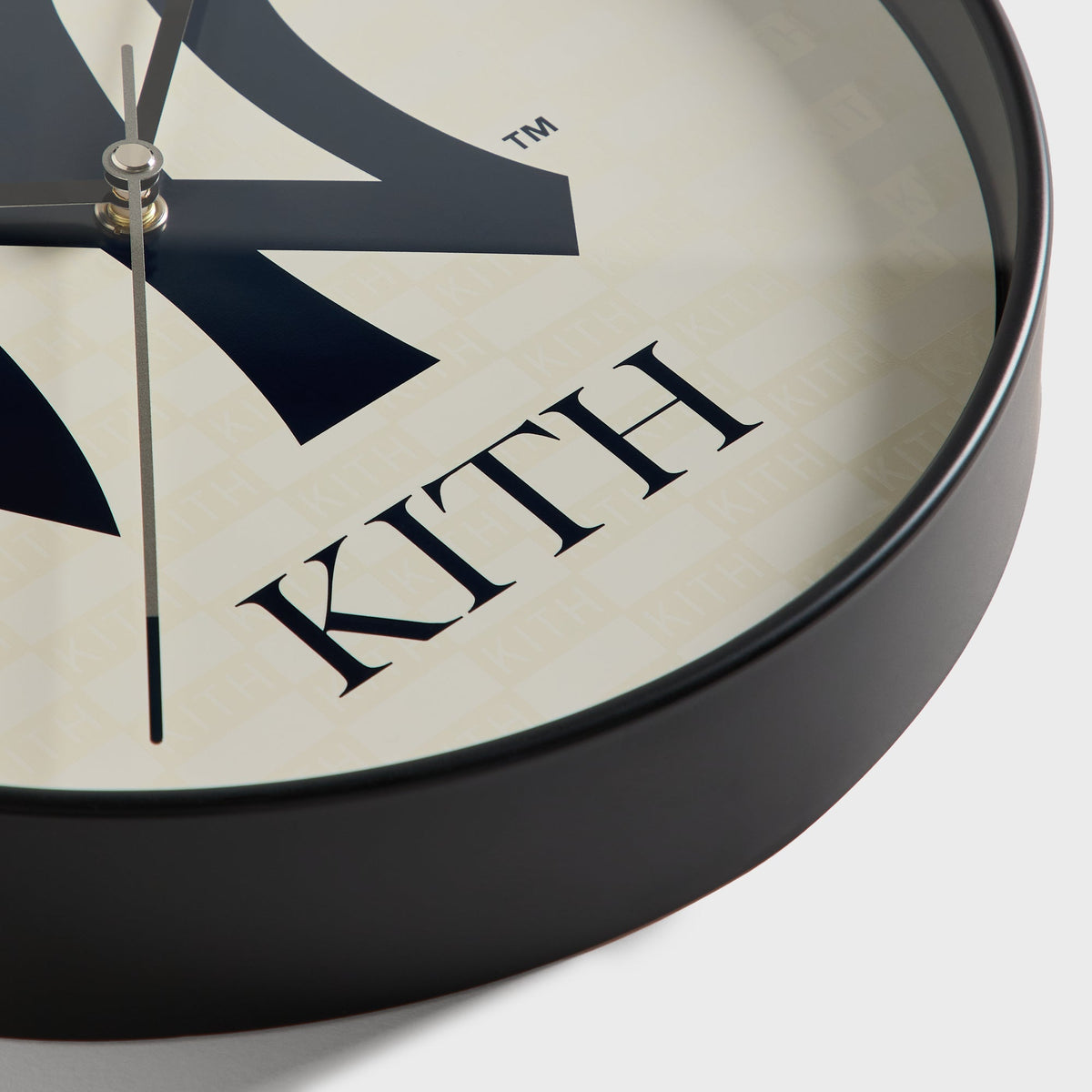 Close-up detail of clock rim and Kith-pattern dial background on the wall clock