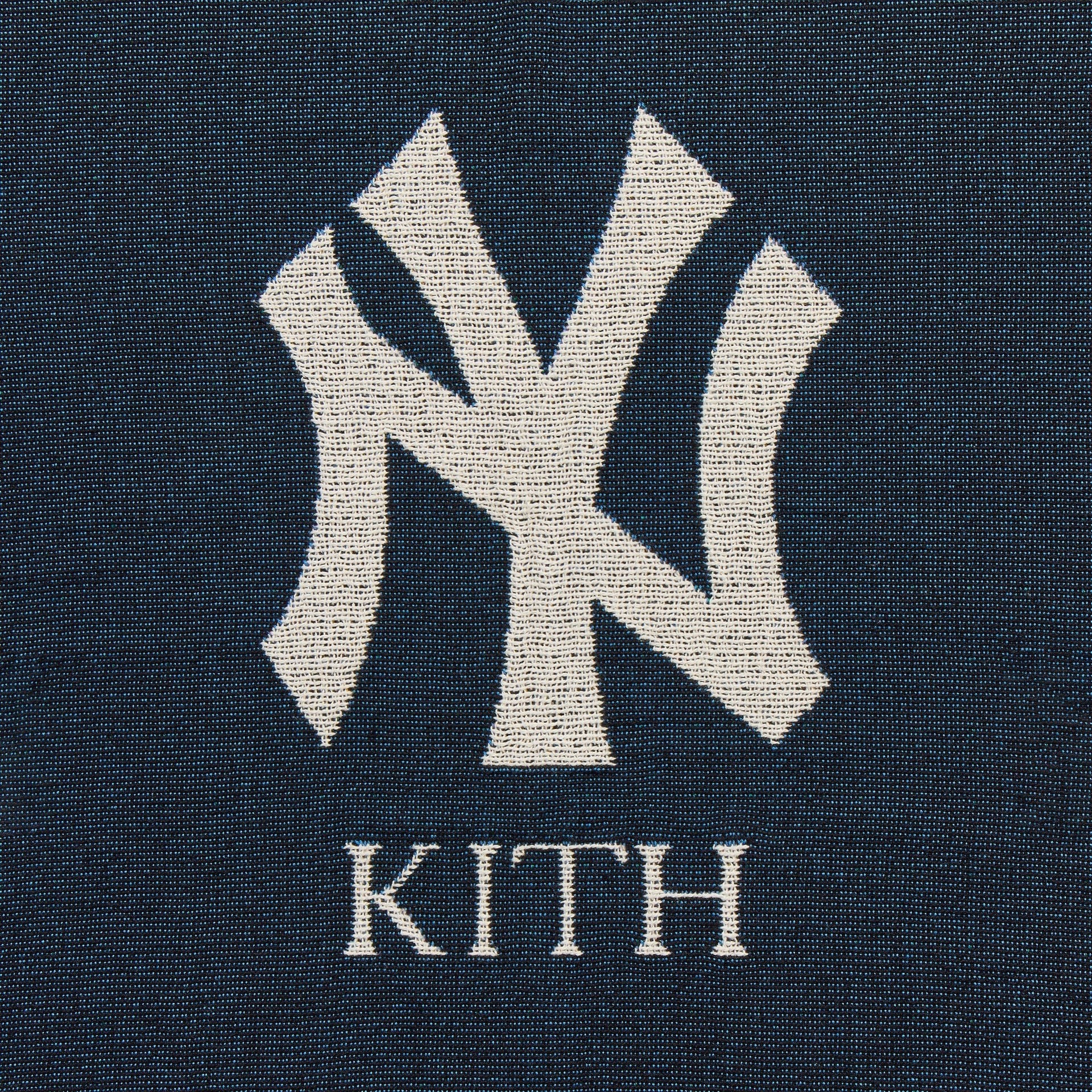 Close-up of woven NY Kith logo in the corner of the Nocturnal tapestry blanket