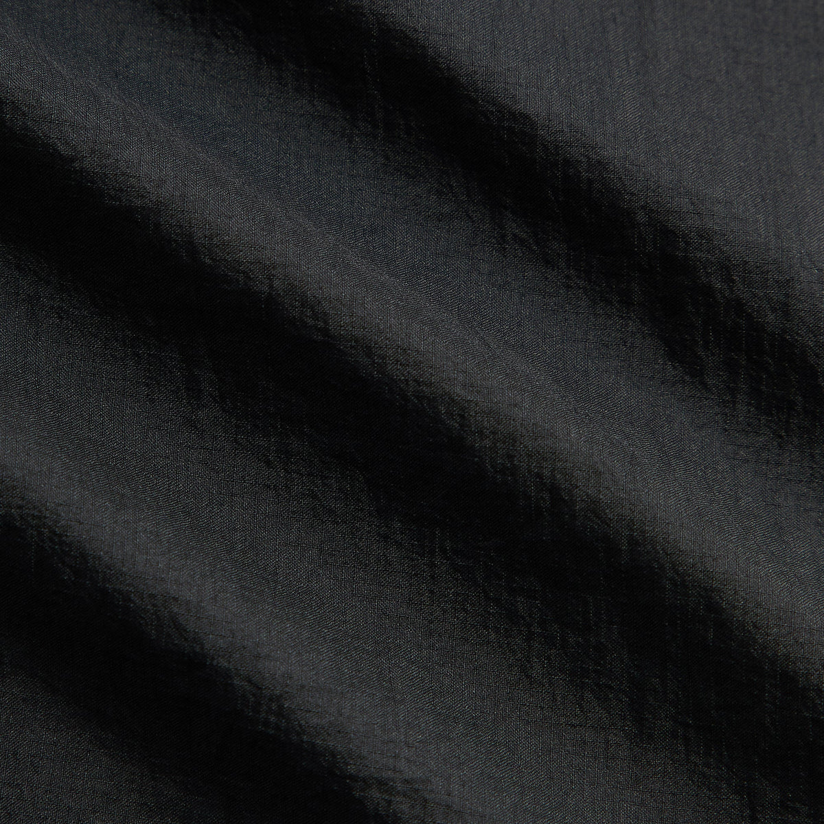 Close-up of Kith Eryx Track Jacket black ripstop fabric texture