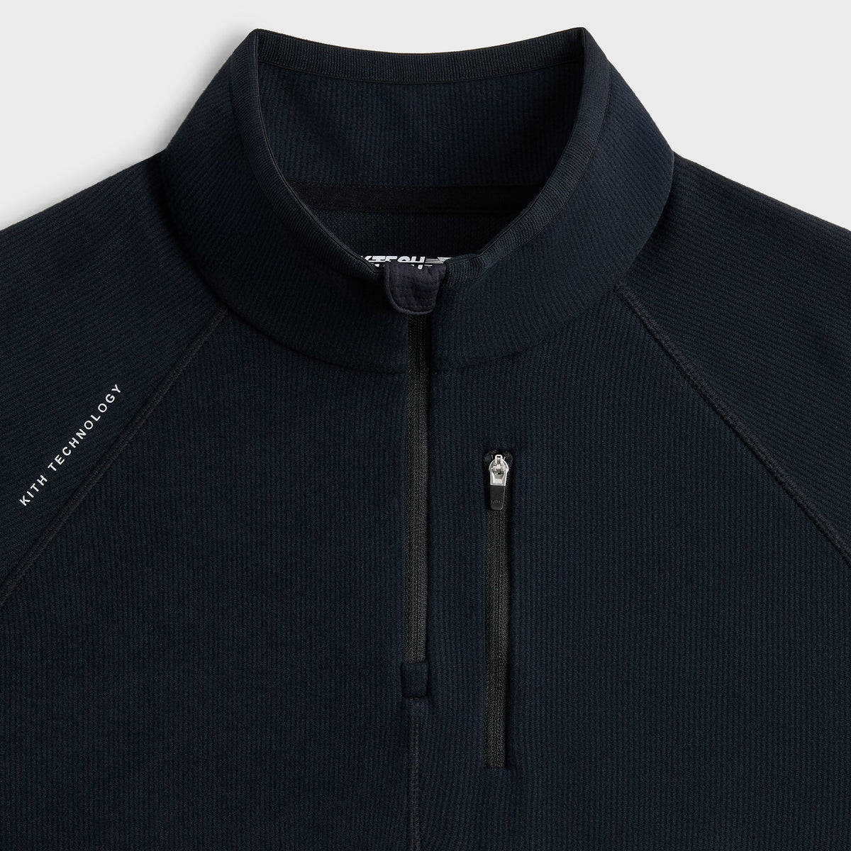 Close-up of Kith Calix Quarter Zip half-zip pull and KTECH wordmark at the collar