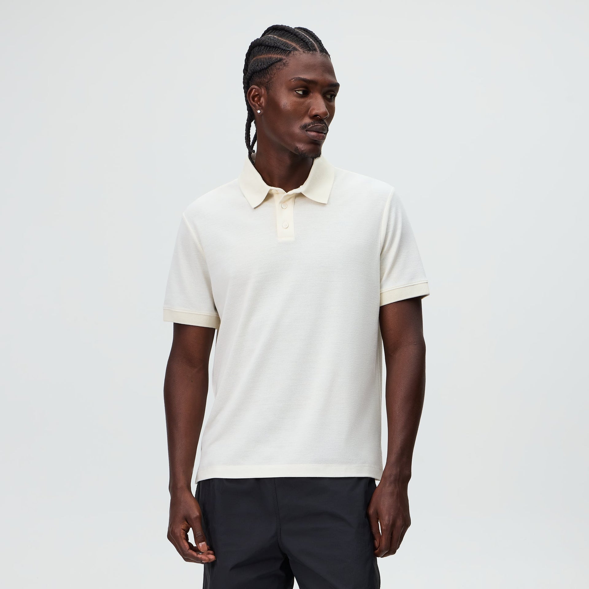 Model wearing the &Kin Melton Polo in White, short-sleeve pique polo, three-quarter view
