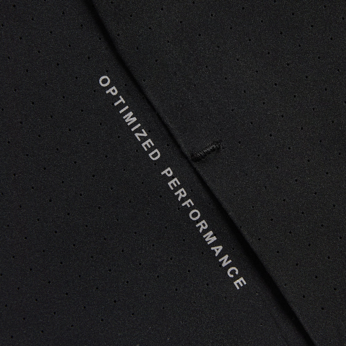 Close-up of Kith Demas 5-inch Short hem reading Optimized Performance in white text