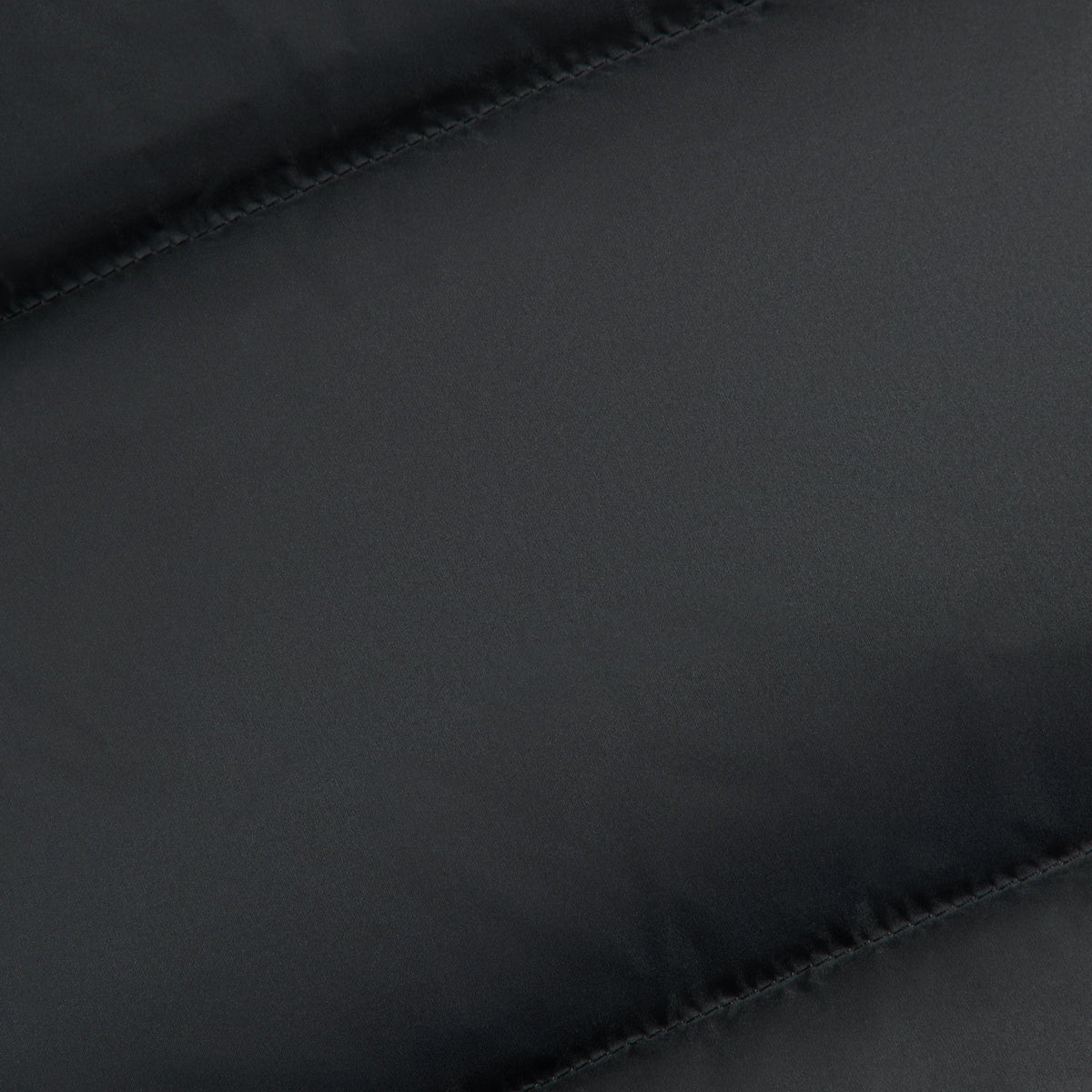 Close-up of black matte taffeta fabric of the Kith midi puffer vest