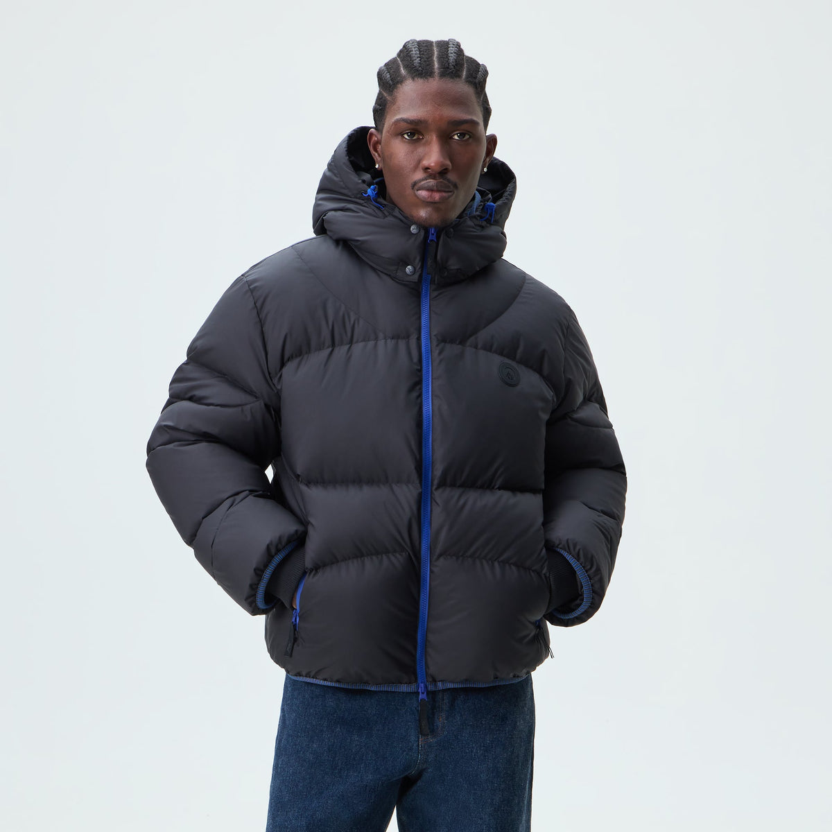 Man wearing black Kith Matte Stretch Taffeta Corey puffer with blue zip, front view