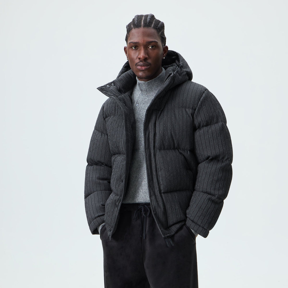 Man wearing charcoal Kith Pleated Tech Maverick puffer jacket, front view