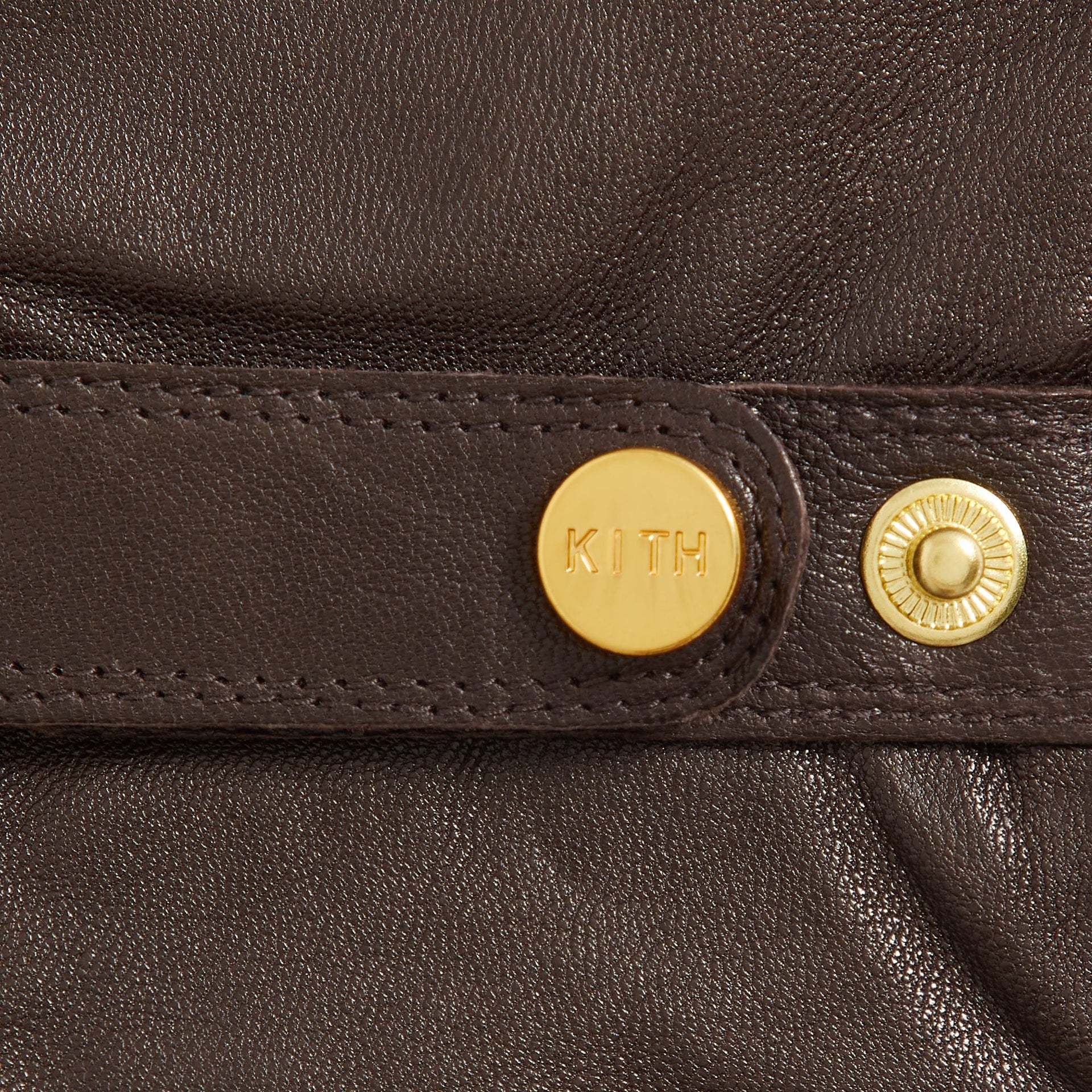 Kith Nappa Leather Manhattan Gloves in Zoom, macro detail of the gold KITH snap button on wrist strap